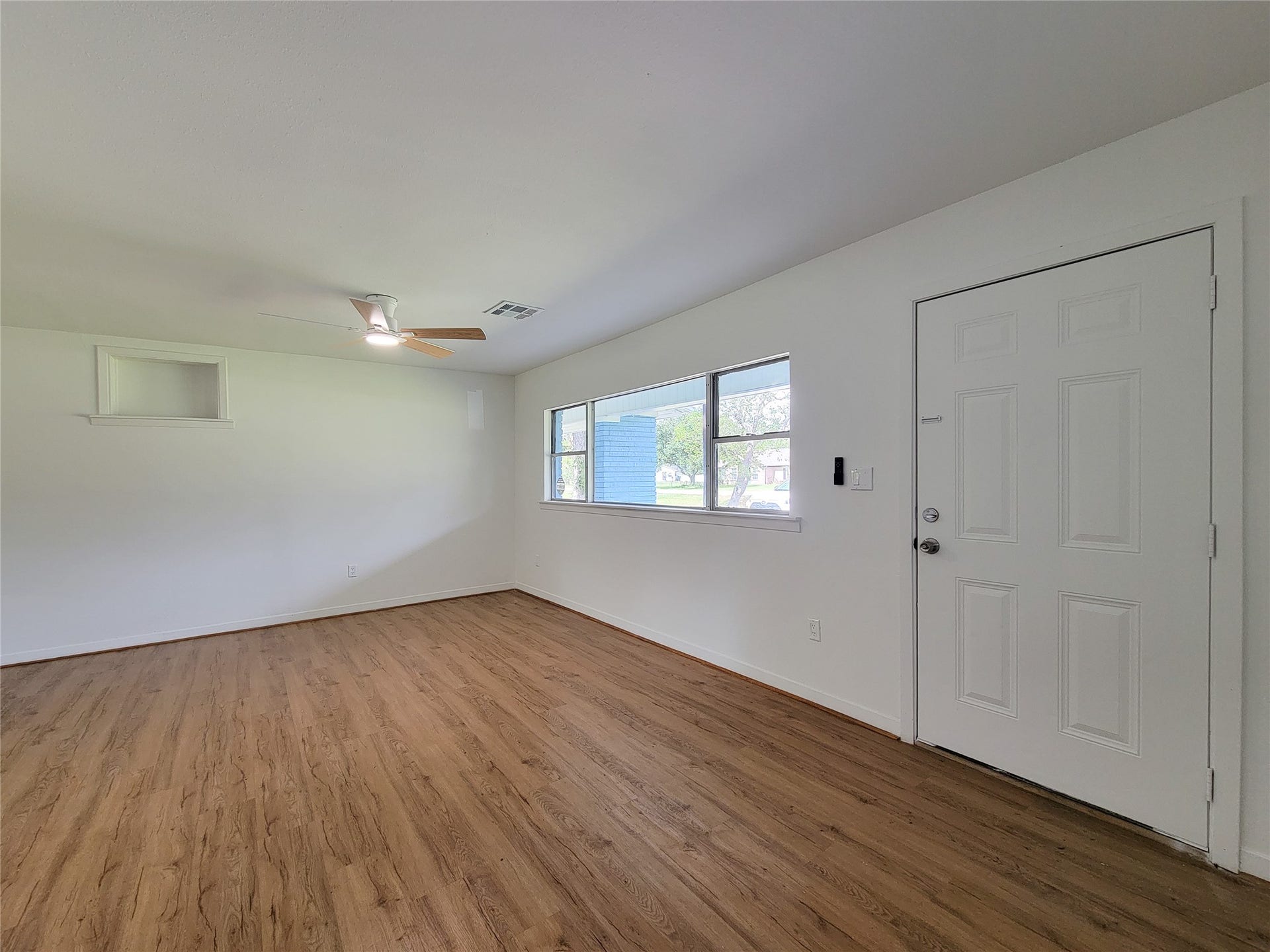2605 W Dumble Street, Alvin, TX 77511 Experience the perfect blend of elegance and comfort in this bright and airy living space, featuring stylish wood flooring, abundant natural light from large windows, and a sleek modern ceiling fan.