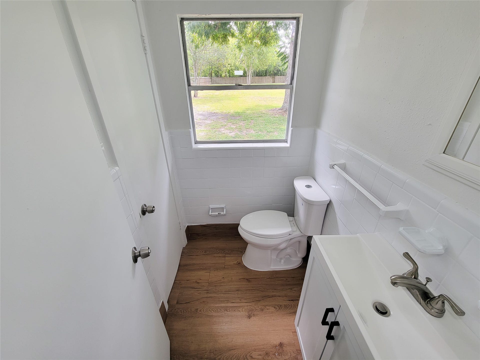 2605 W Dumble Street, Alvin, TX 77511 Bright and inviting bathroom with a modern sink, sleek fixtures, and a large window overlooking the lush backyard.