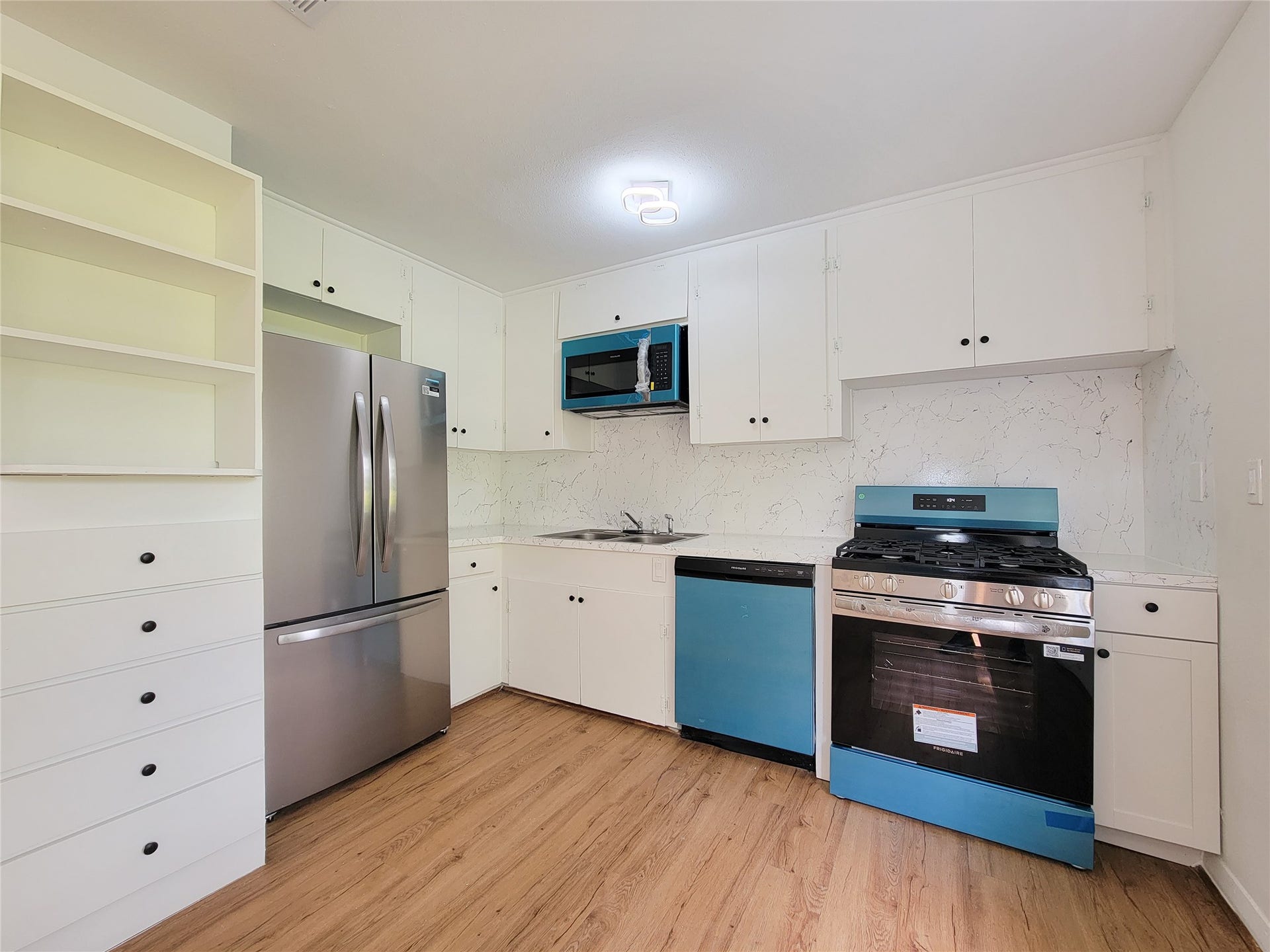 2605 W Dumble Street, Alvin, TX 77511 Discover the perfect blend of modern elegance with sleek stainless steel appliances, ample white cabinetry, and stylish wood flooring in this contemporary kitchen.