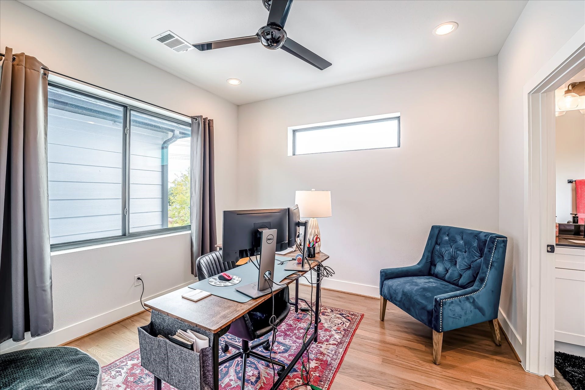 Spacious secondary bedroom featuring hardwood flooring, large windows, and flexible use for family or guests. Photos reflect previous furnishings. Home is currently vacant. Furnishings shown are for illustrative purposes only.