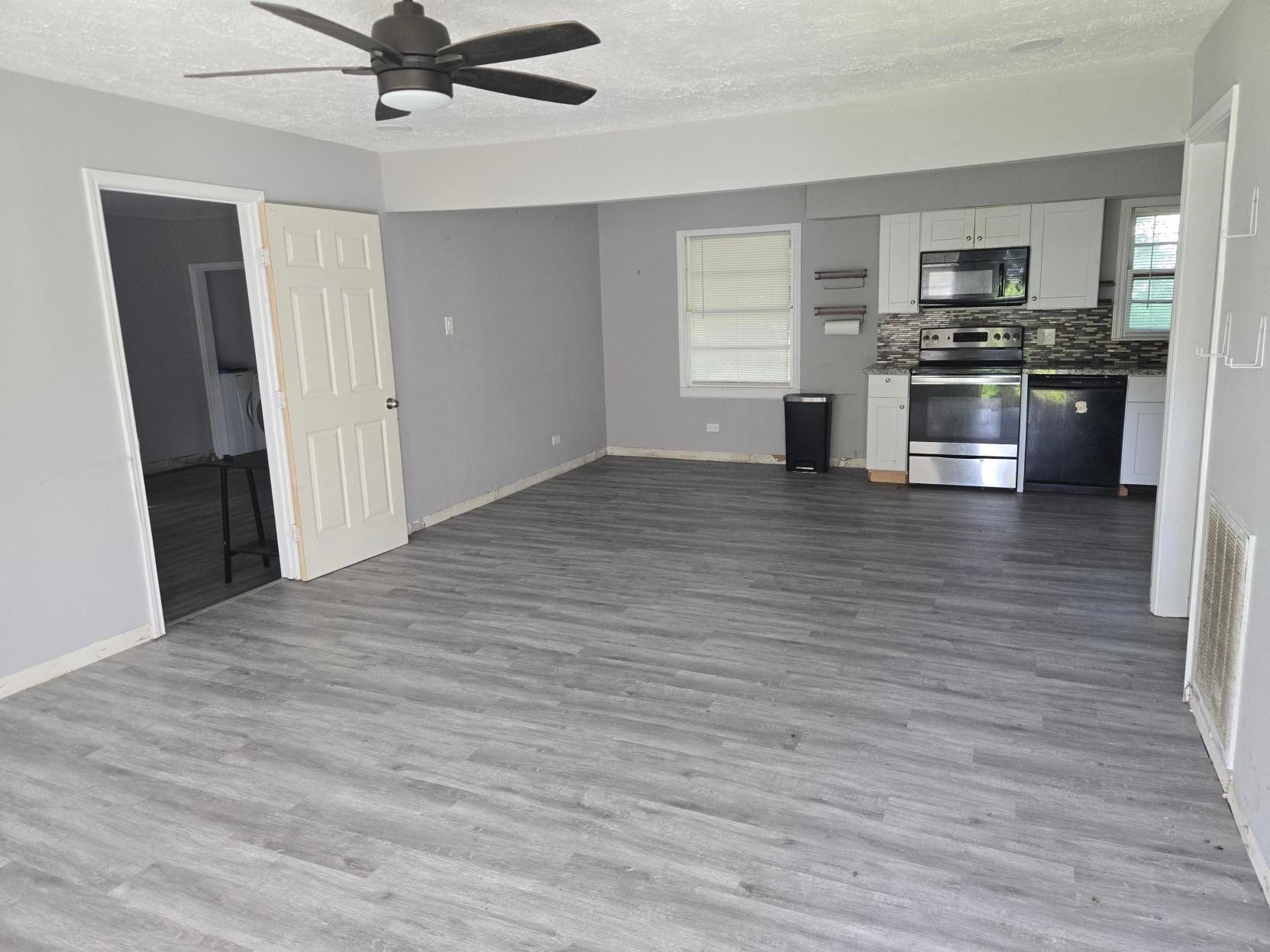 4611 Nevada, Dickinson, TX 77539 A spacious, modern living area with flooring, and a kitchen featuring stainless steel appliances.