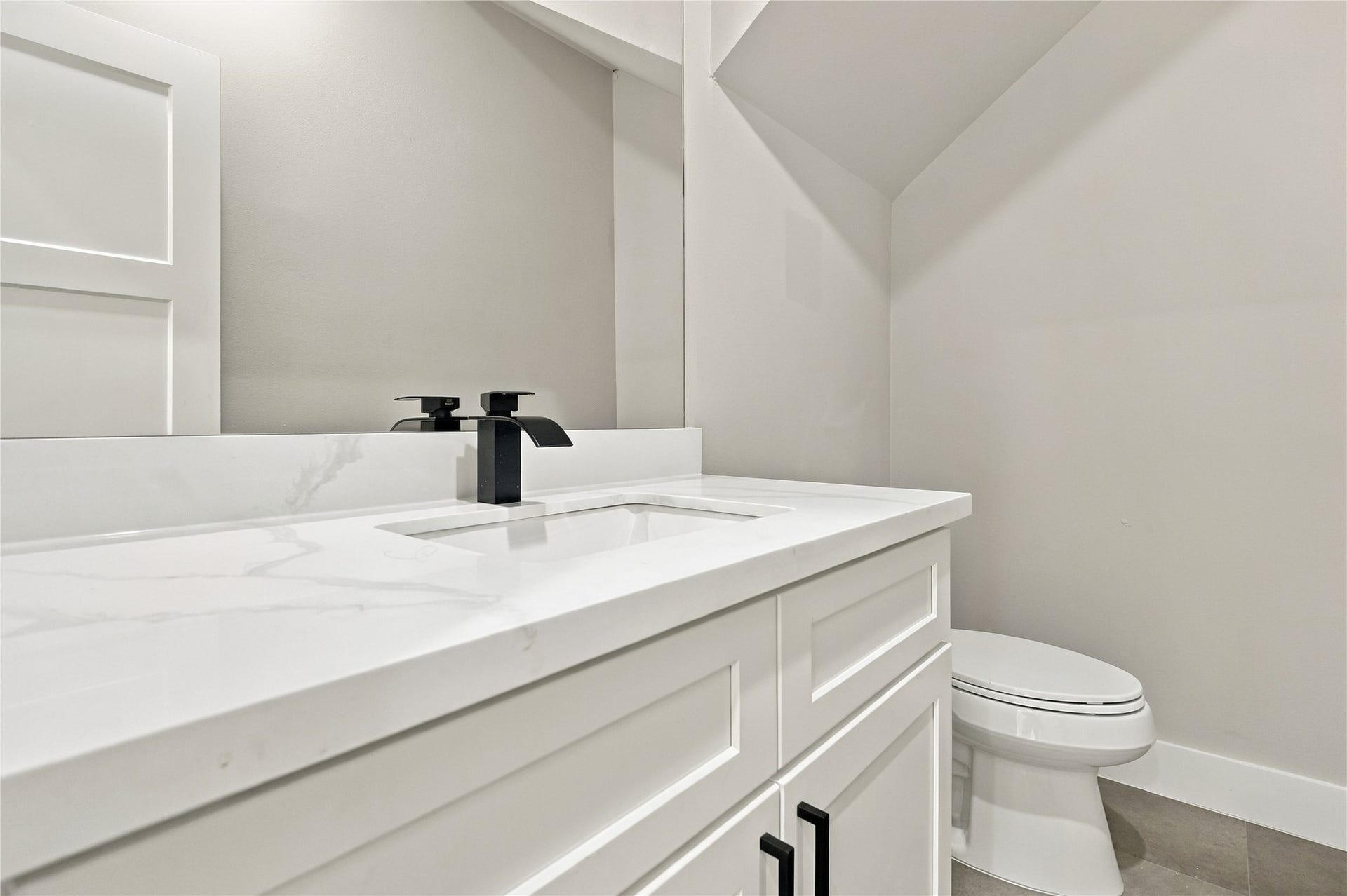 4313 Clover Street, #A/B, Houston, TX 77051 Elegant bathroom featuring a sleek marble vanity with modern black fixtures and a clean, minimalist design.