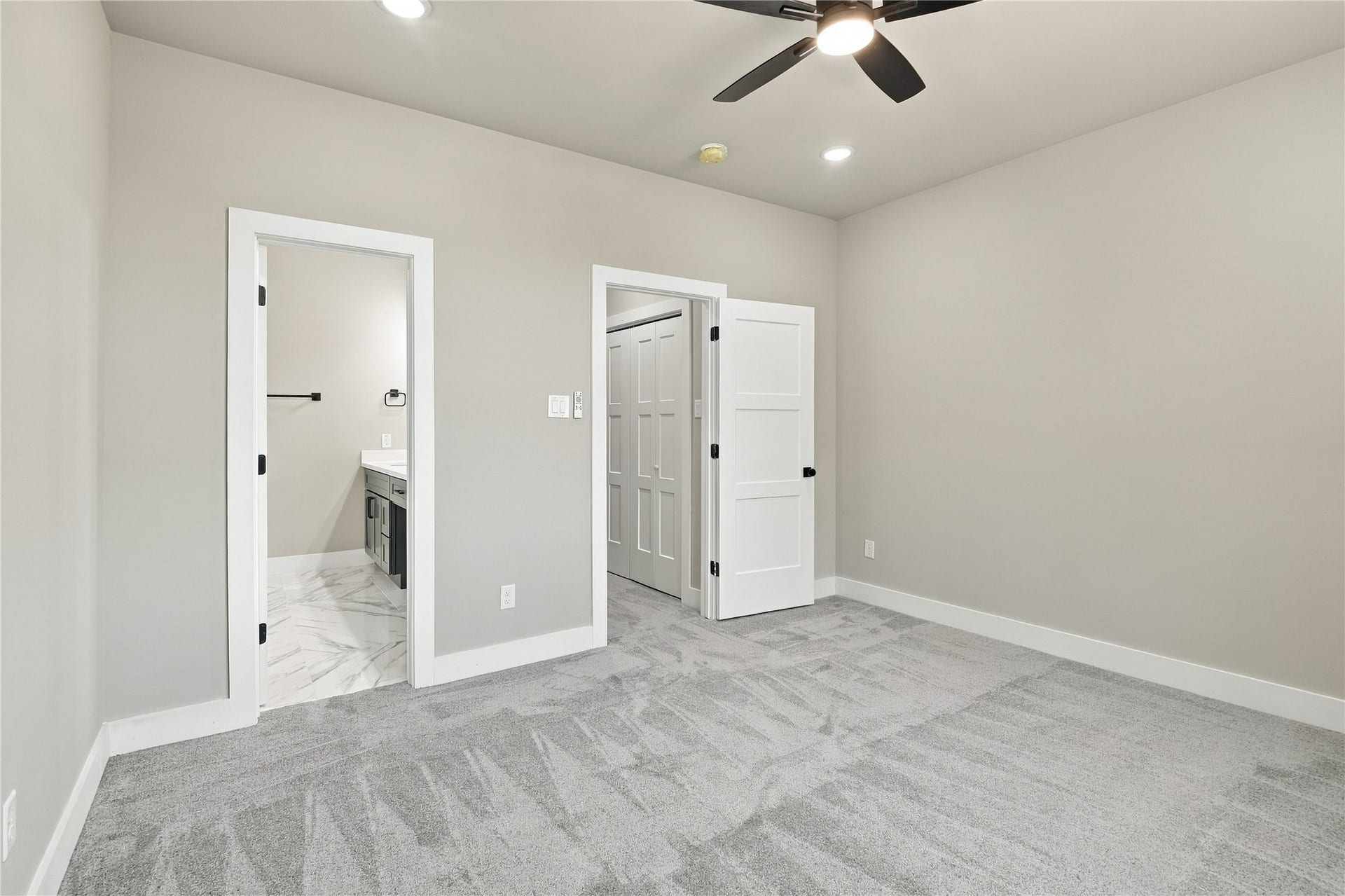 4313 Clover Street, #A/B, Houston, TX 77051 Spacious bedroom with plush carpet, modern ceiling fan, and direct access to a sleek en-suite bathroom.