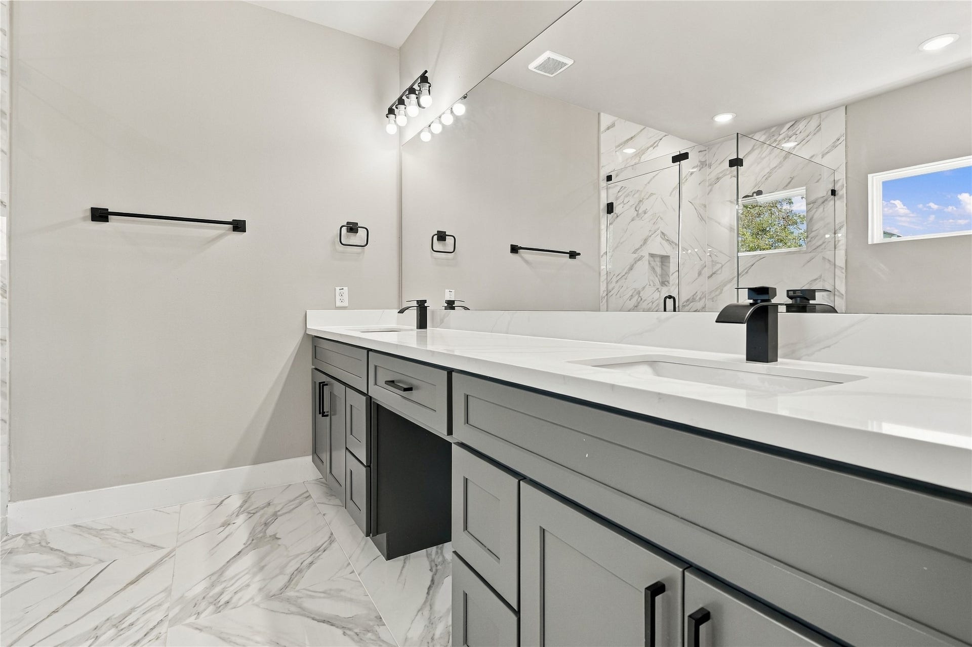 4313 Clover Street, #A/B, Houston, TX 77051 Luxurious bathroom featuring a sleek double vanity with modern fixtures, elegant marble flooring, and a spacious glass-enclosed shower.