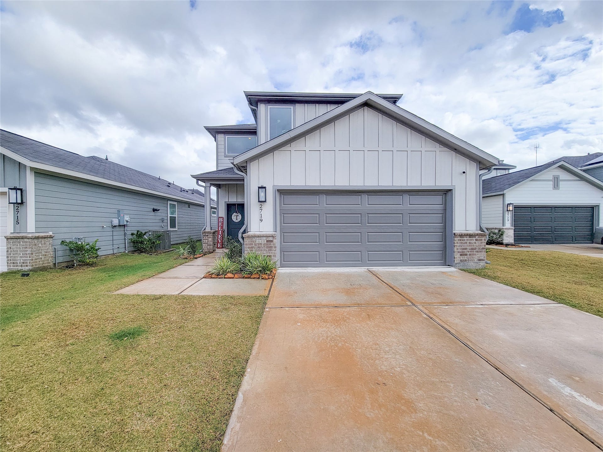 2719 Forest Retreat Lane, Missouri City, TX 77489 Modern two-story home with a clean, gray exterior and a spacious two-car garage. Features a well-maintained front lawn and a welcoming entrance.