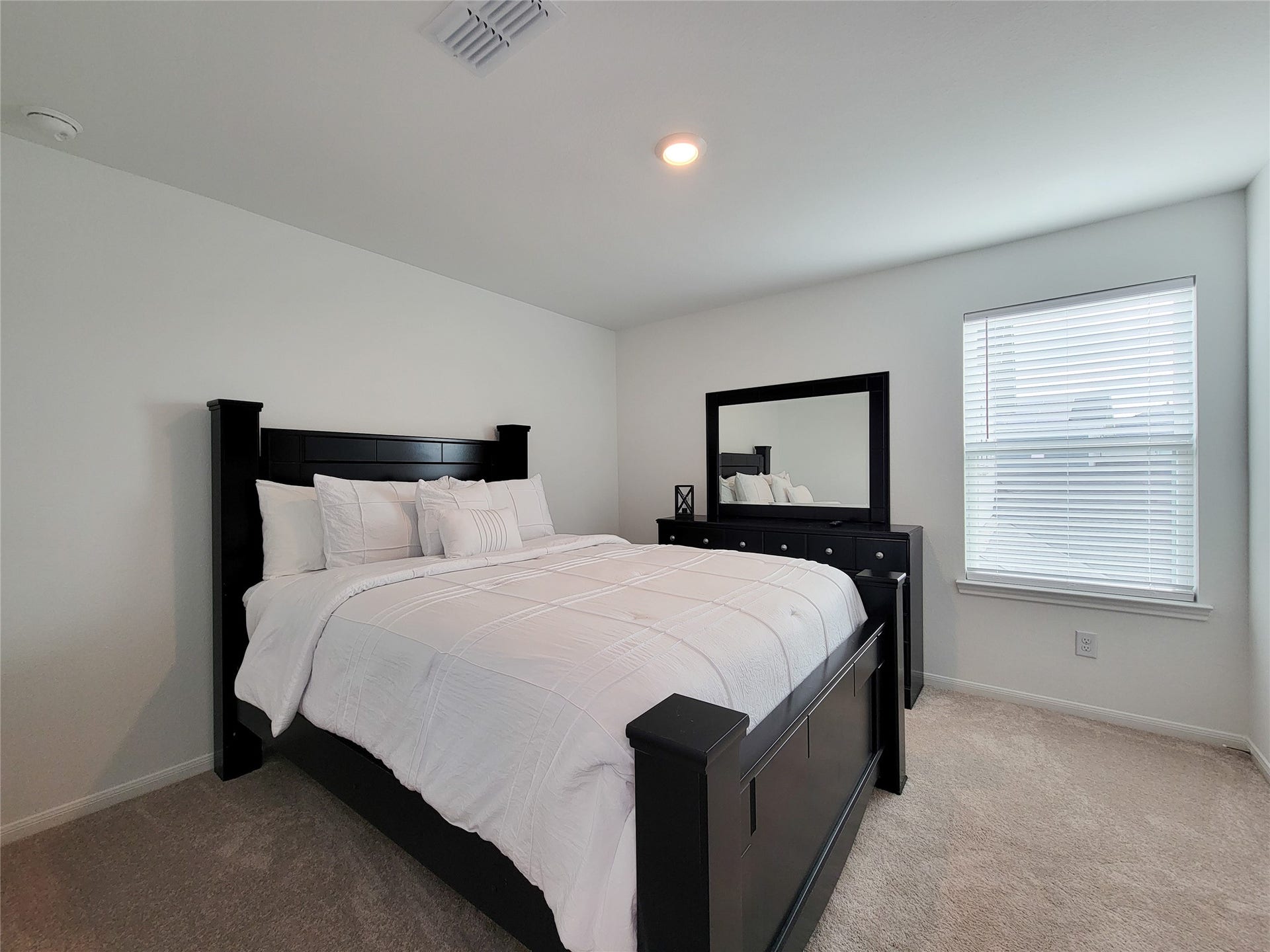 2719 Forest Retreat Lane, Missouri City, TX 77489 Cozy bedroom featuring. Natural light fills the room through a window with blinds, creating a bright and inviting atmosphere.