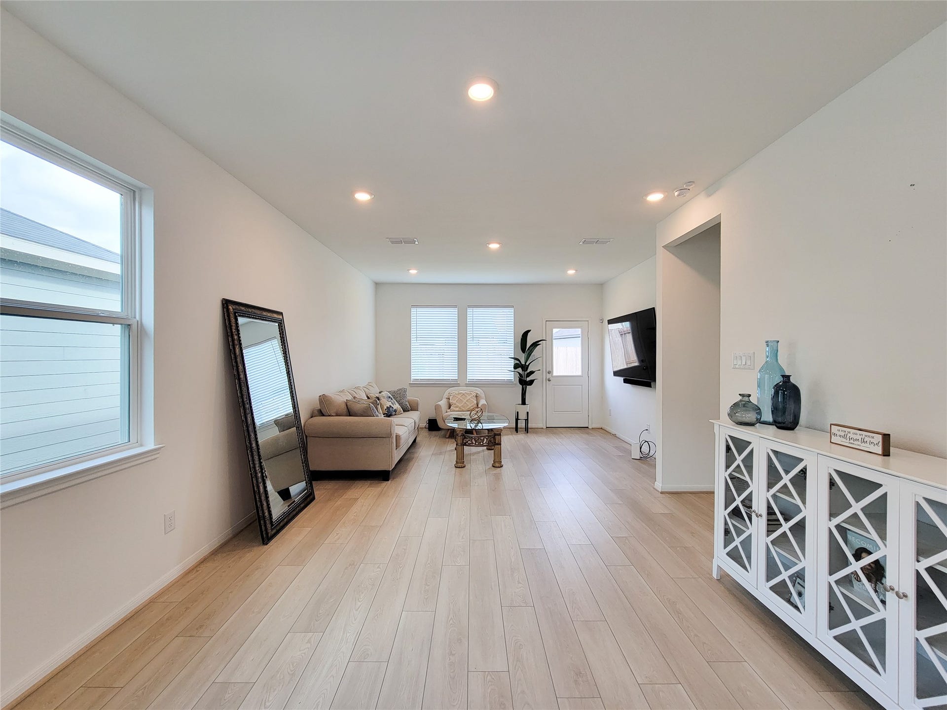 2719 Forest Retreat Lane, Missouri City, TX 77489 This bright, modern living room features light wood flooring, neutral walls, and ample natural light from large windows.