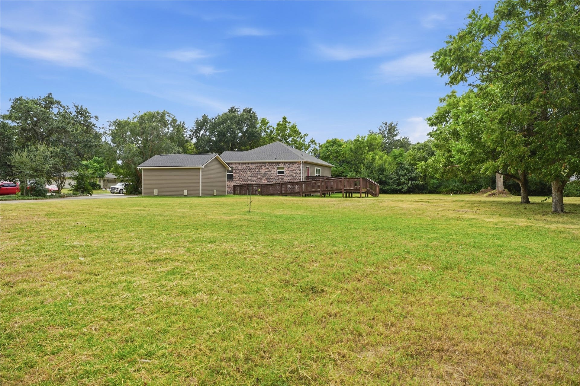 102 20th Avenue N, Texas City, TX 77590 A wide view of the yard shows the home, detached garage, and access ramp leading to the back entrance.