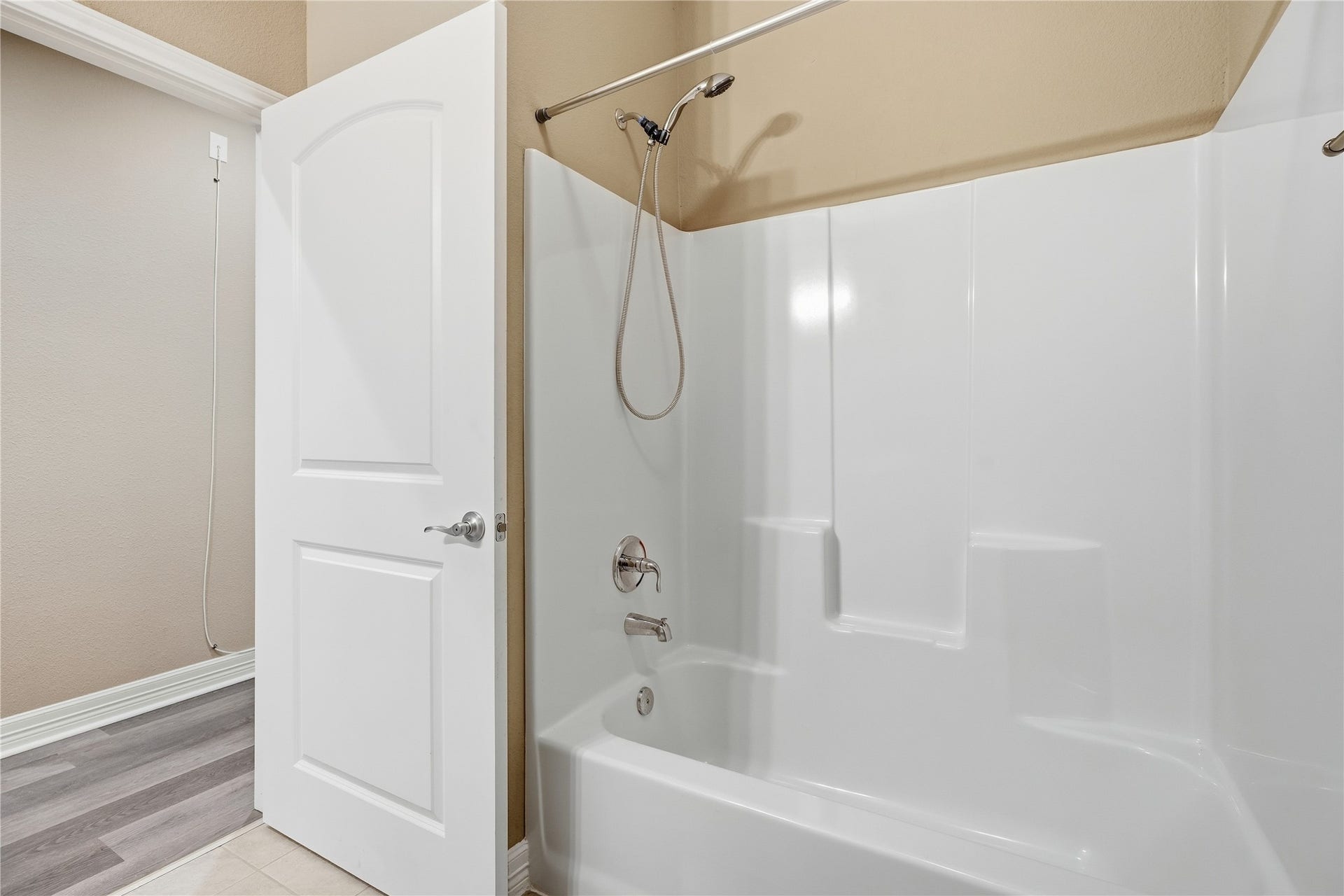 102 20th Avenue N, Texas City, TX 77590 A tub and shower combination with a handheld showerhead and built-in shelves for bath essentials.