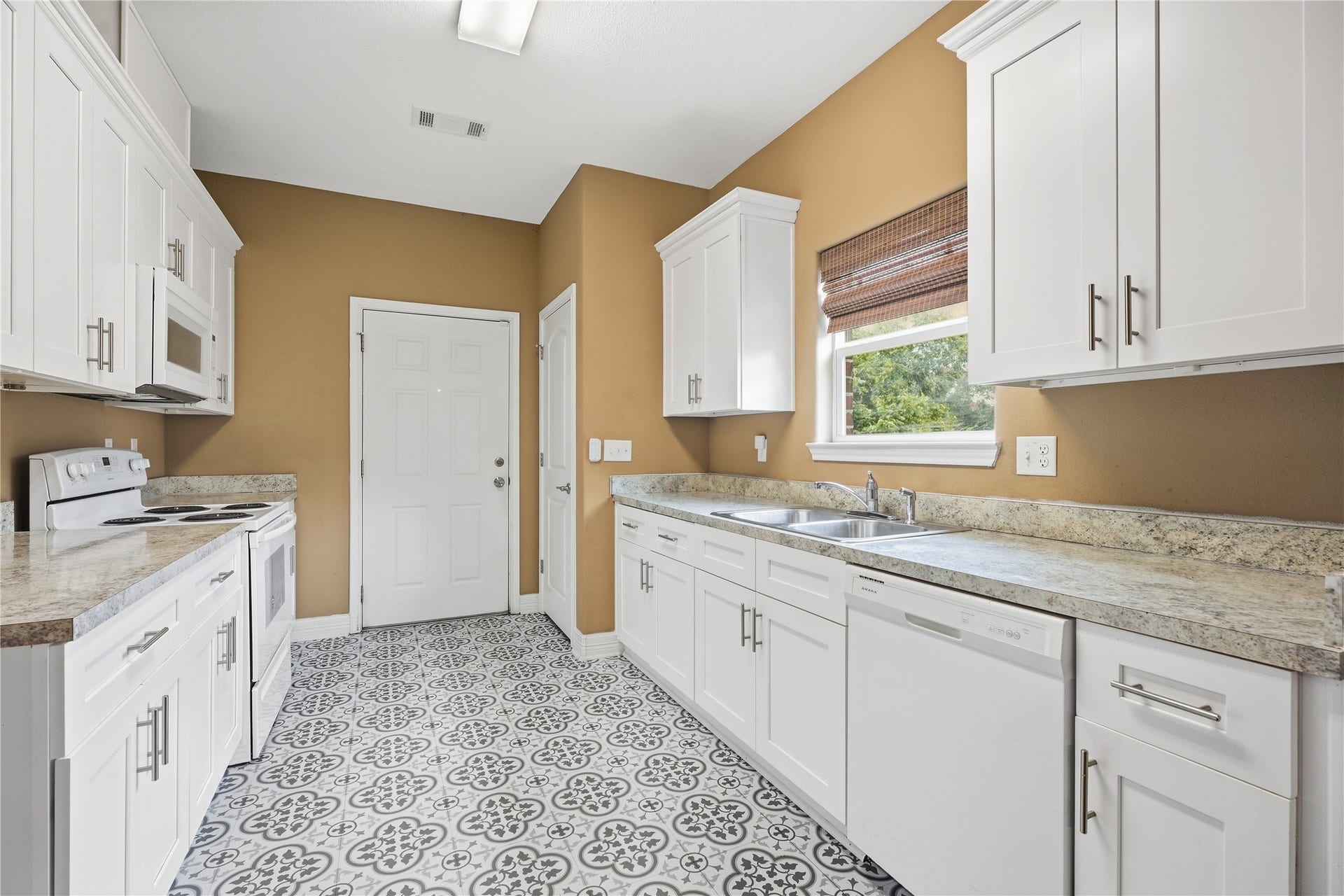 102 20th Avenue N, Texas City, TX 77590 A window above the double sink brings in natural light and a view of the yard, with the dishwasher conveniently beside it.