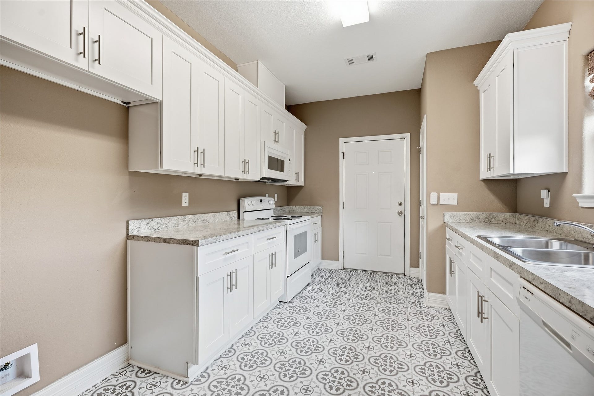 102 20th Avenue N, Texas City, TX 77590 The kitchens galley layout keeps everything within reach, with an electric range, overhead microwave, and cabinets on both sides.