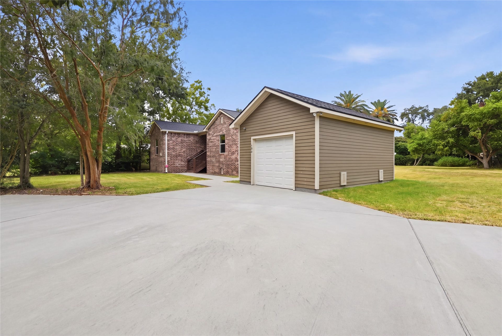 102 20th Avenue N, Texas City, TX 77590 A spacious yard with mature trees and room for gardening or outdoor activities alongside the detached garage.
