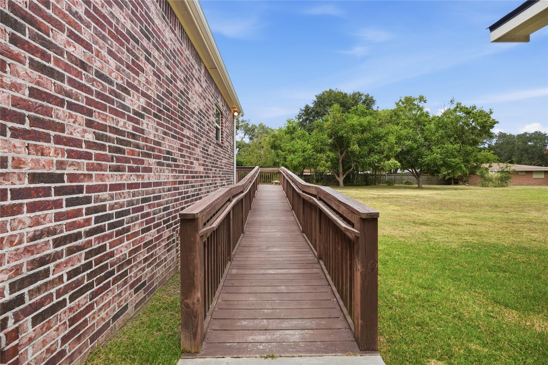 102 20th Avenue N, Texas City, TX 77590 An access ramp with handrails on both sides leads to the back entrance, providing an alternative to the steps.