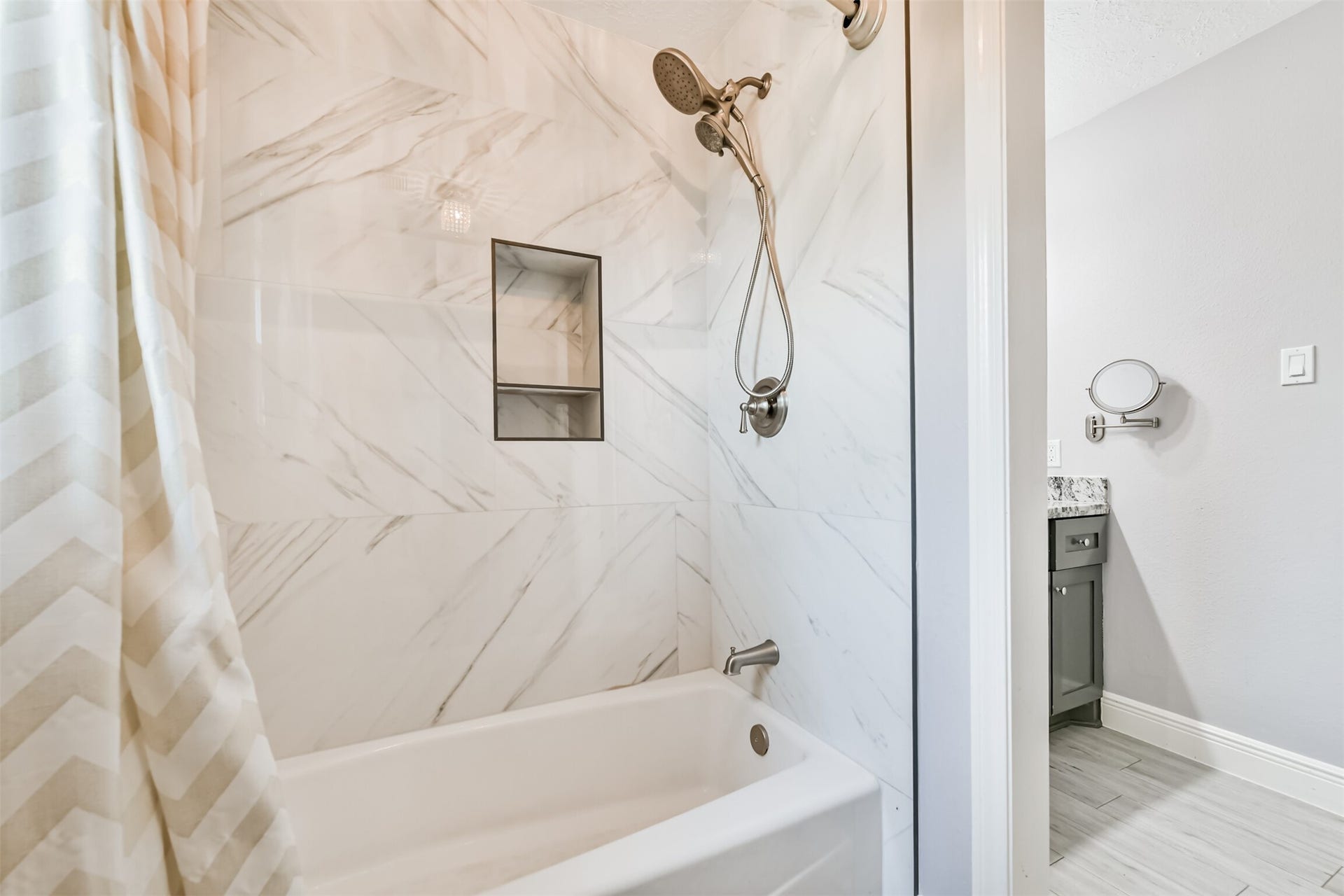 9311 Masters Road, Manvel, TX 77578 Luxurious full bath featuring elegant marble-style tiles and modern fixtures for a spa-like experience.