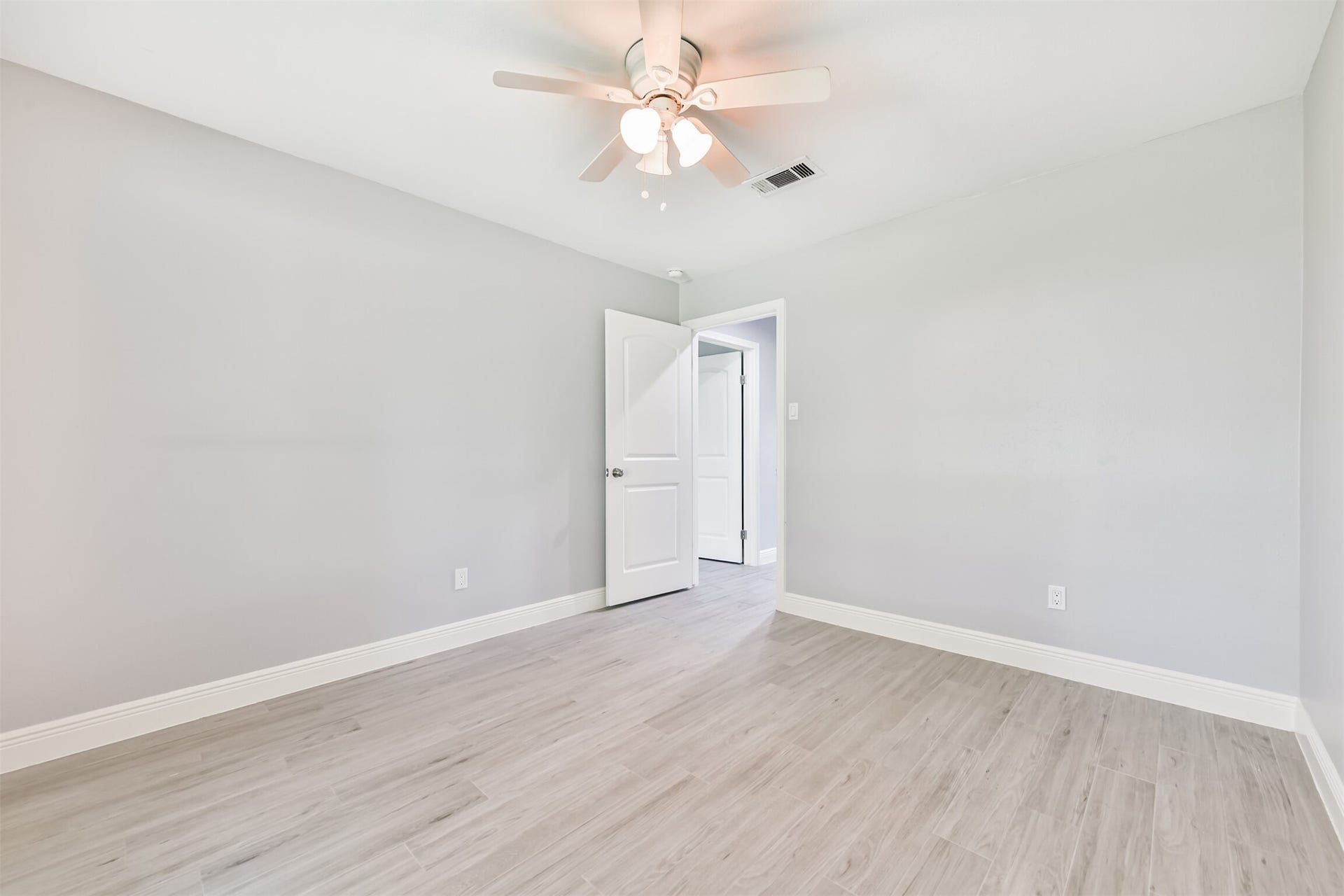 9311 Masters Road, Manvel, TX 77578 Bright and inviting, this spacious bedroom features sleek flooring and a modern ceiling fan, perfect for comfort and style.