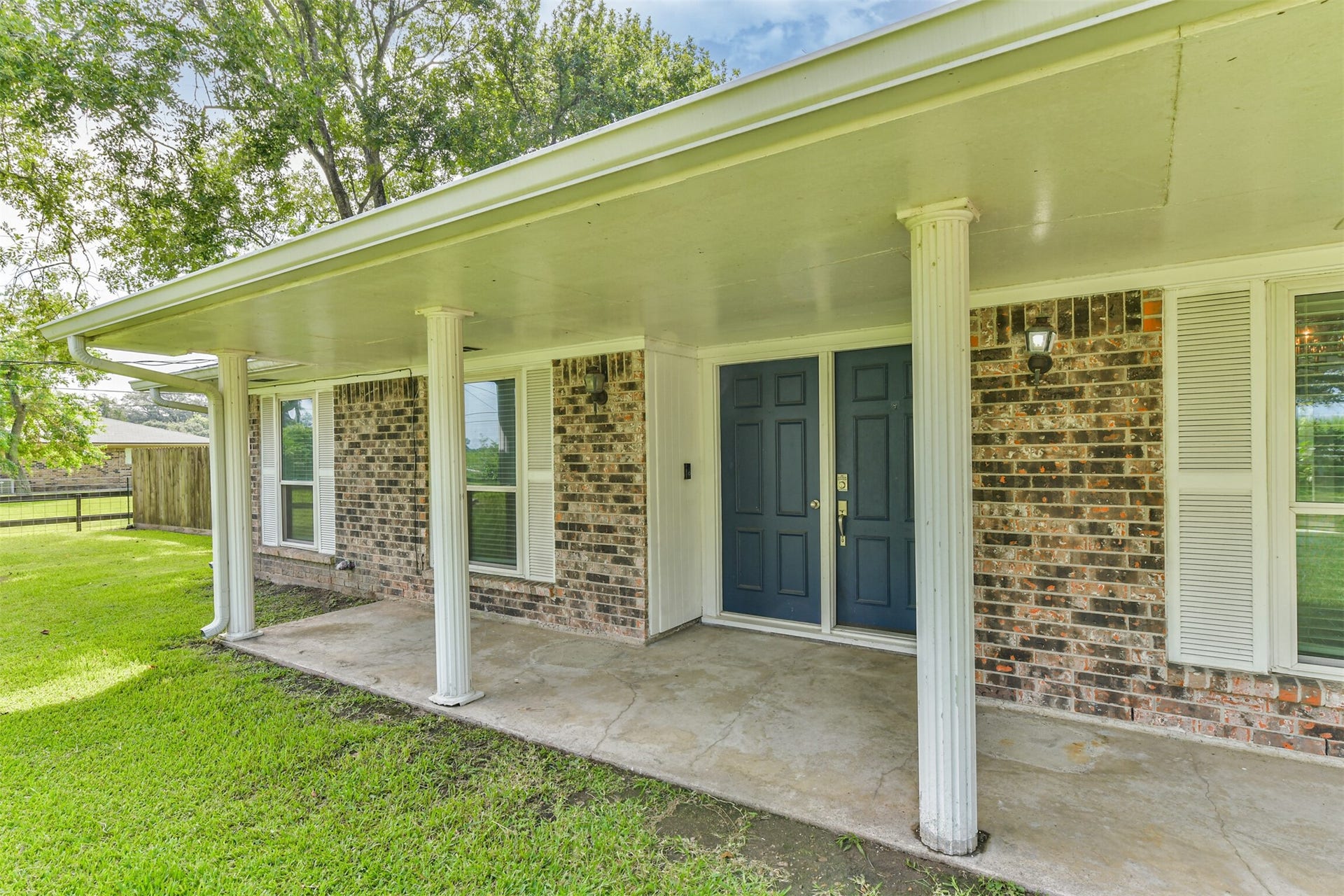 9311 Masters Road, Manvel, TX 77578 Welcoming front porch with classic columns and a serene view, perfect for relaxing afternoons.