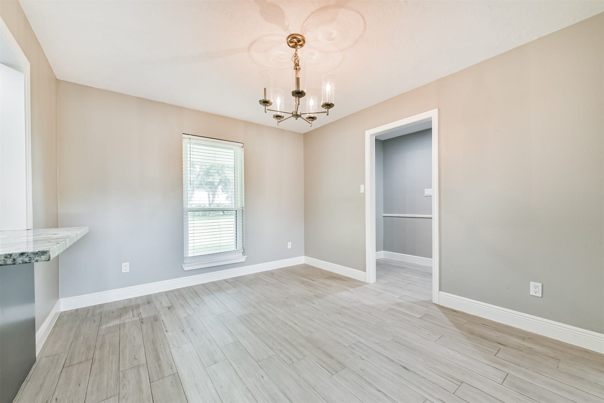9311 Masters Road, Manvel, TX 77578 Bright and inviting breakfast nook featuring elegant wood flooring, a stylish chandelier, and a large window for natural light. Perfect for morning coffee and casual dining.