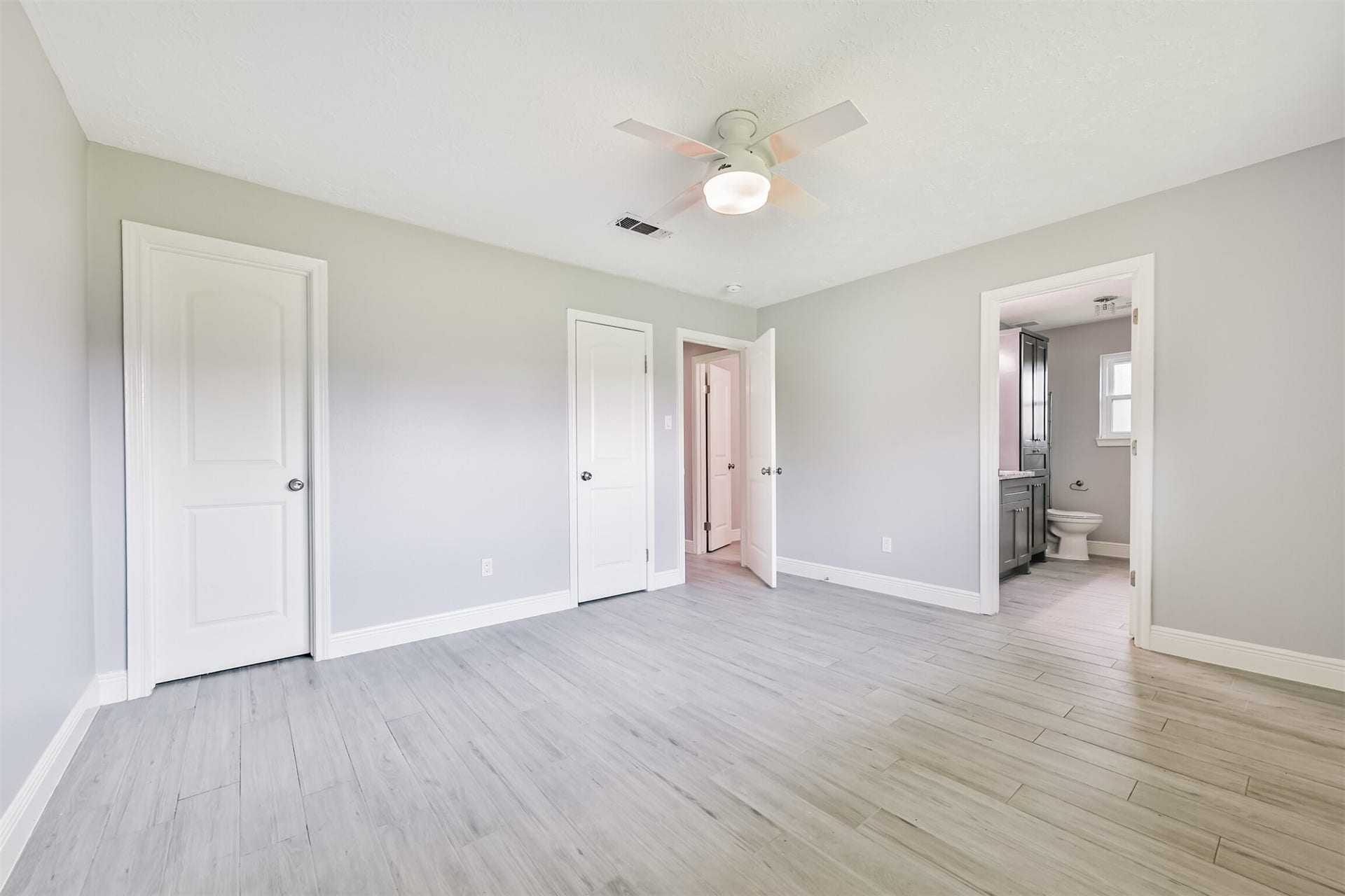 9311 Masters Road, Manvel, TX 77578 Spacious primary bedroom with modern flooring, ample natural light, and an en-suite bathroom for ultimate comfort.