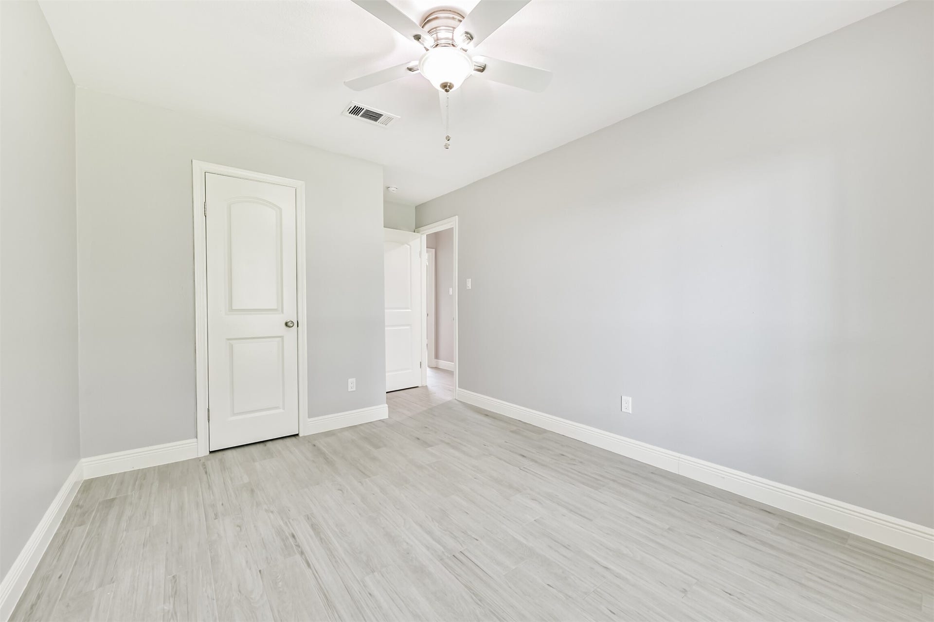 9311 Masters Road, Manvel, TX 77578 Here is a bright and inviting bedroom, featuring fresh neutral tones, sleek flooring, and a modern ceiling fan, perfect for a cozy retreat.