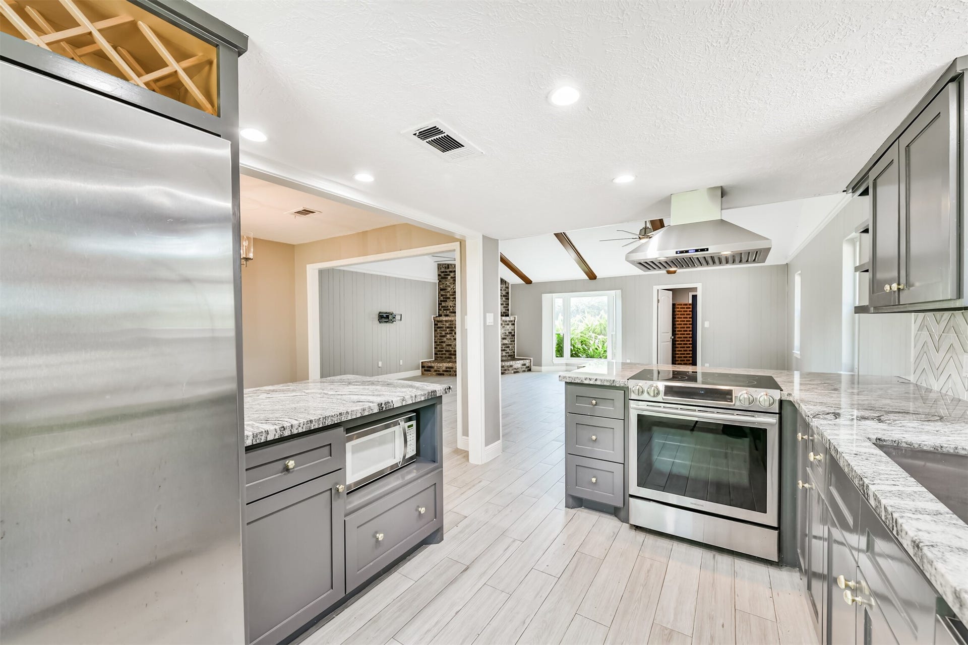 9311 Masters Road, Manvel, TX 77578 Modern kitchen featuring sleek granite countertops, stainless steel appliances, and ample cabinetry, seamlessly connecting to an inviting living area.