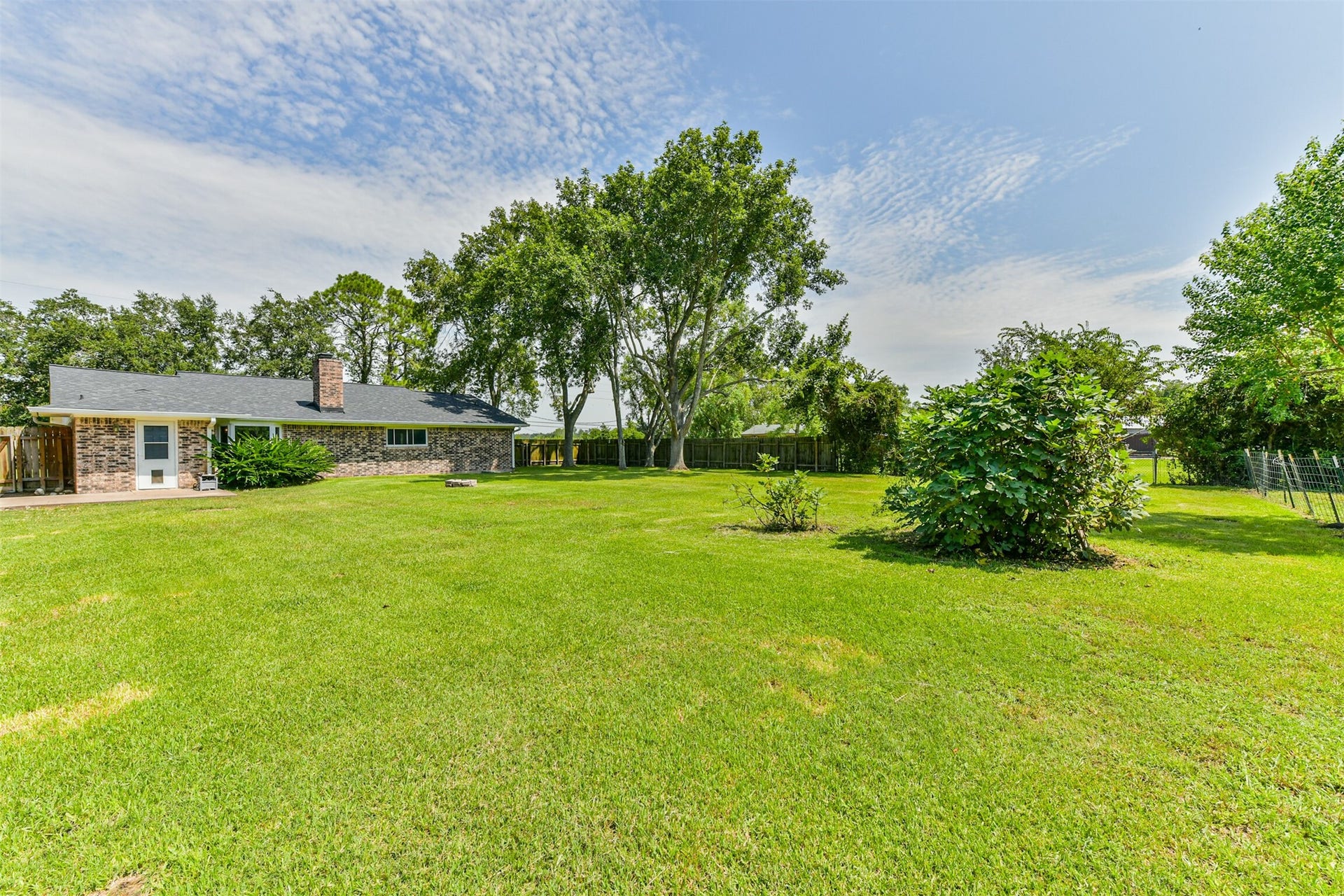 9311 Masters Road, Manvel, TX 77578 Expansive backyard with lush greenery, perfect for outdoor gatherings and relaxation.