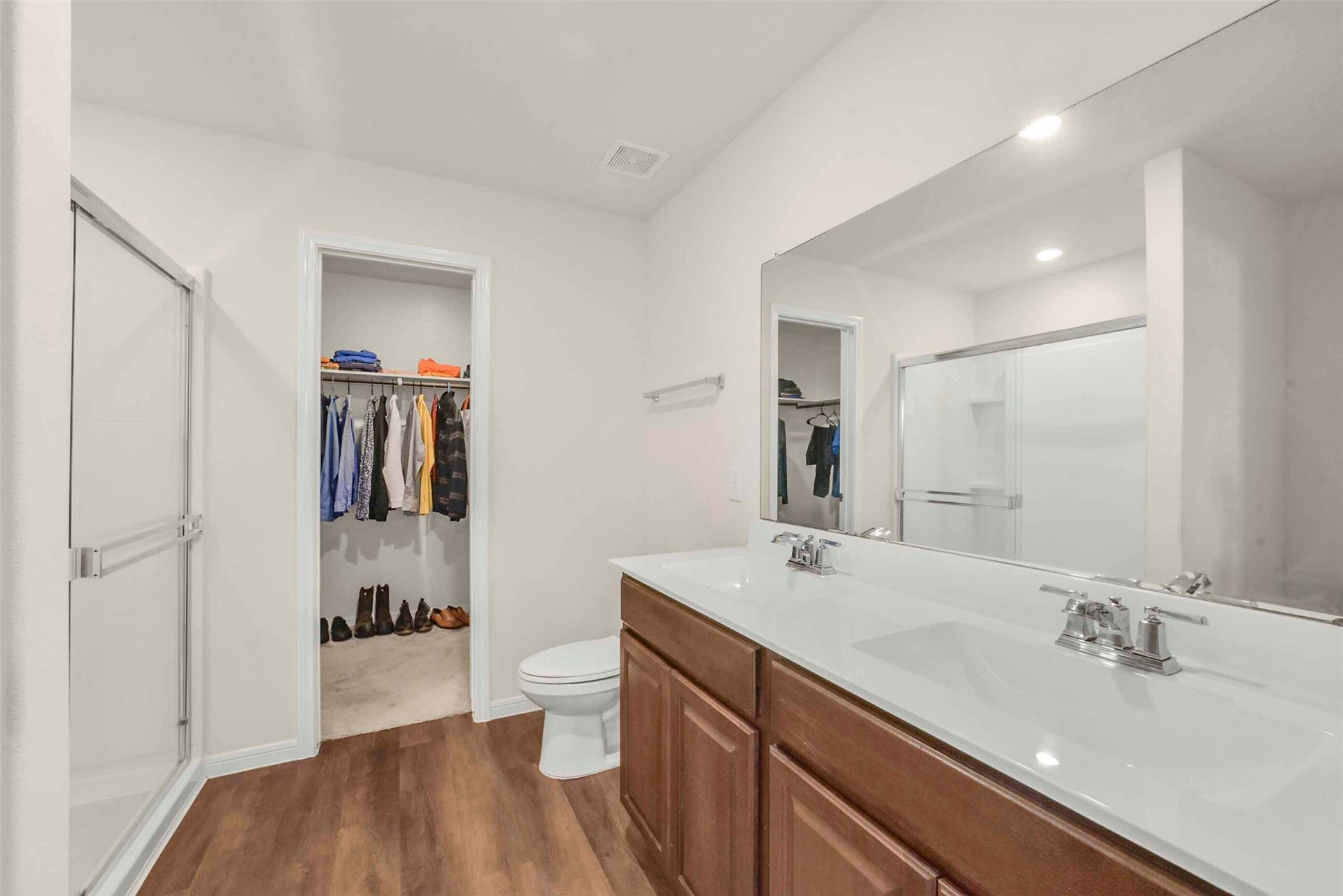 Double sinks in primary bathroom boasting a huge primary closet.
