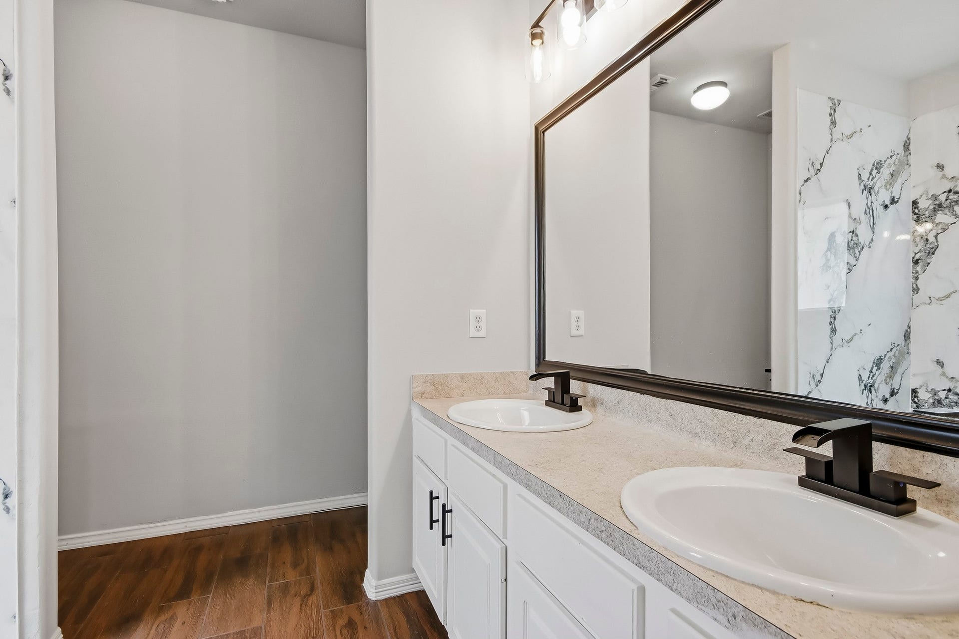 10023 Checkerberry Park Lane, Tomball, TX 77375 Step into an en-suite primary bathroom that highlights modern luxury and convenience. A wide vanity setup features dual sink basins, broad counter surface area, and expansive cabinetry.