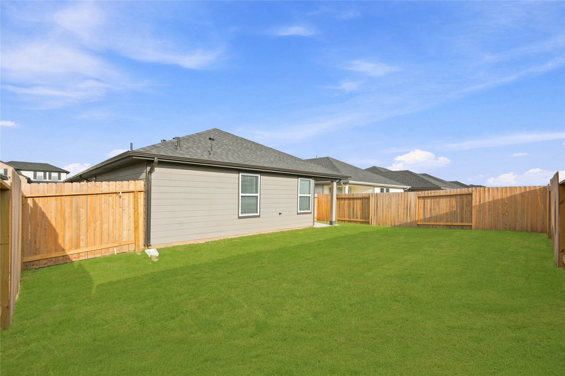 Spacious backyard with covered patio.