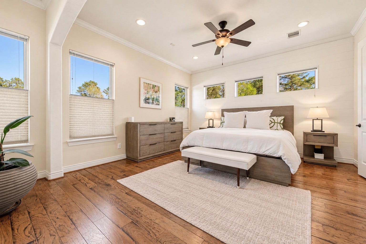 Primary bedroom featuring hardwood floors, spacious layout and neutral finishes. AI-generated image depicting a potential wall paint color.