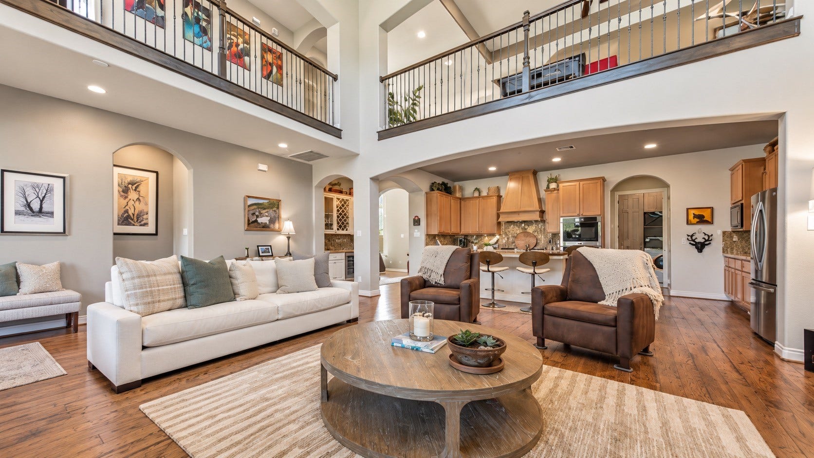 Open living space featuring high ceilings, fireplace, built-ins and views into the adjoining areas.