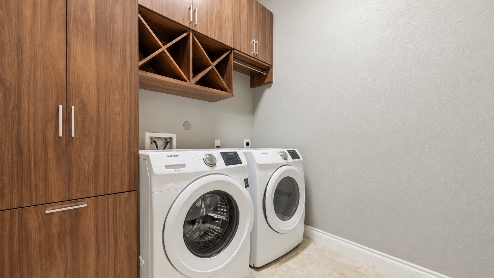 Convenient laundry room featuring built-in cabinetry and full-size washer and dryer.