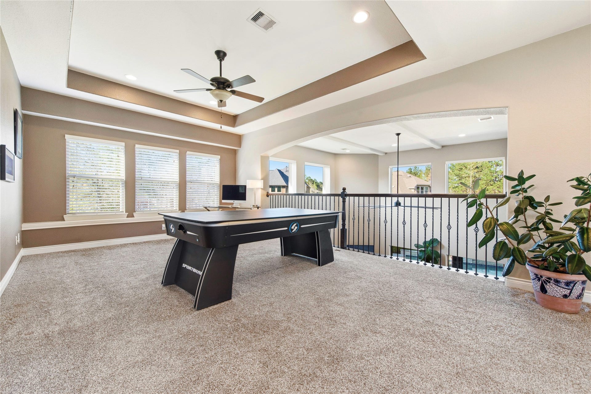 Expansive game room featuring multiple seating areas, abundant natural light and open-concept design.