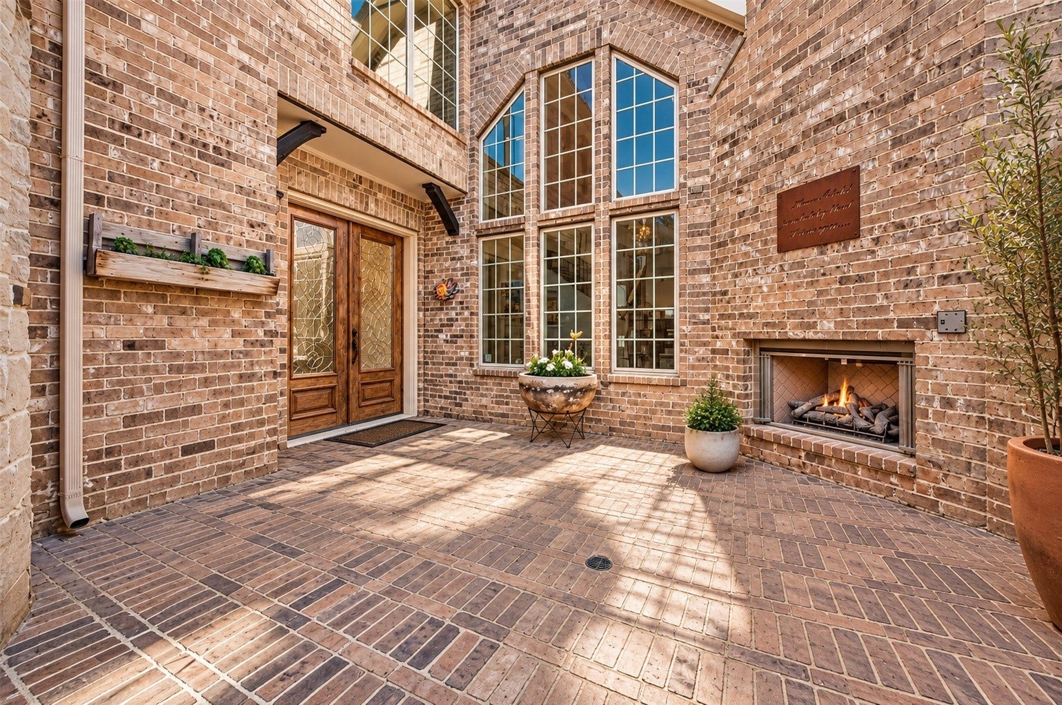 Private courtyard showcasing brick architecture, landscaping and abundant natural light.