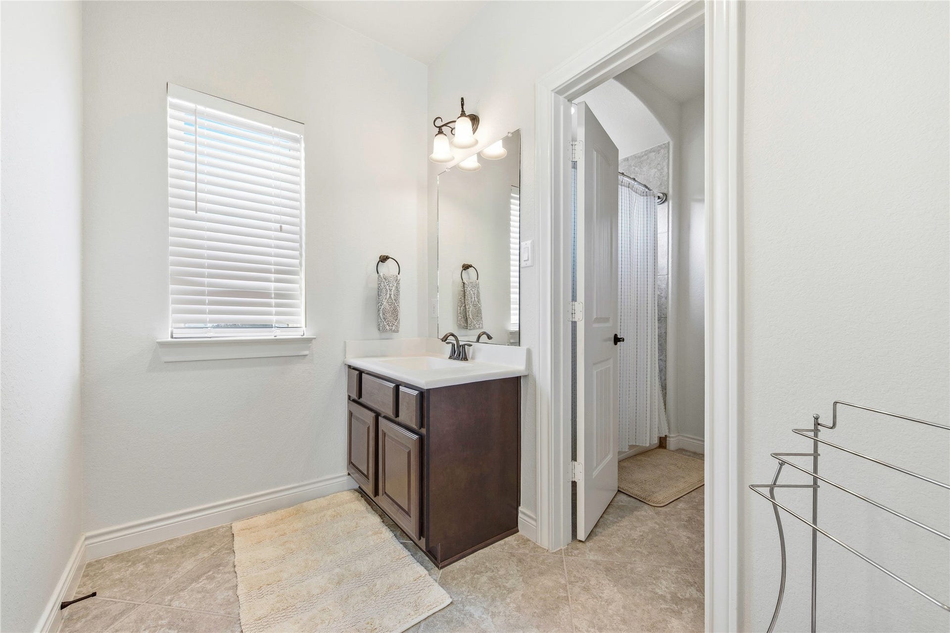 Well-appointed bathroom featuring vanity, mirror and walk-in shower.