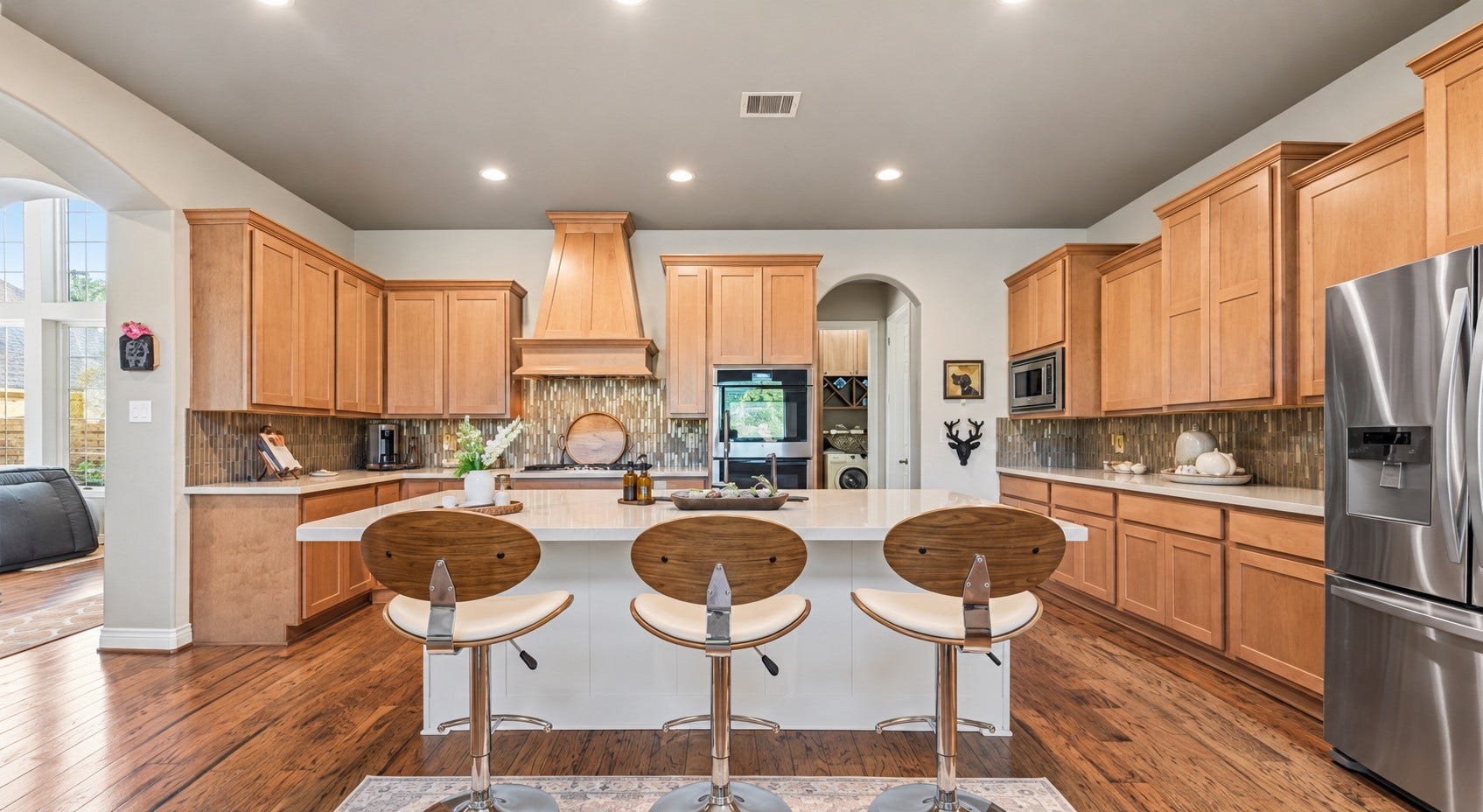 Gourmet kitchen featuring custom cabinetry, spacious island, bar seating and stainless appliances.