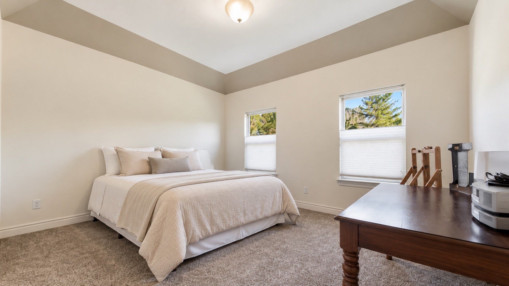 Secondary bedroom featuring vaulted ceiling, neutral finishes and spacious layout.