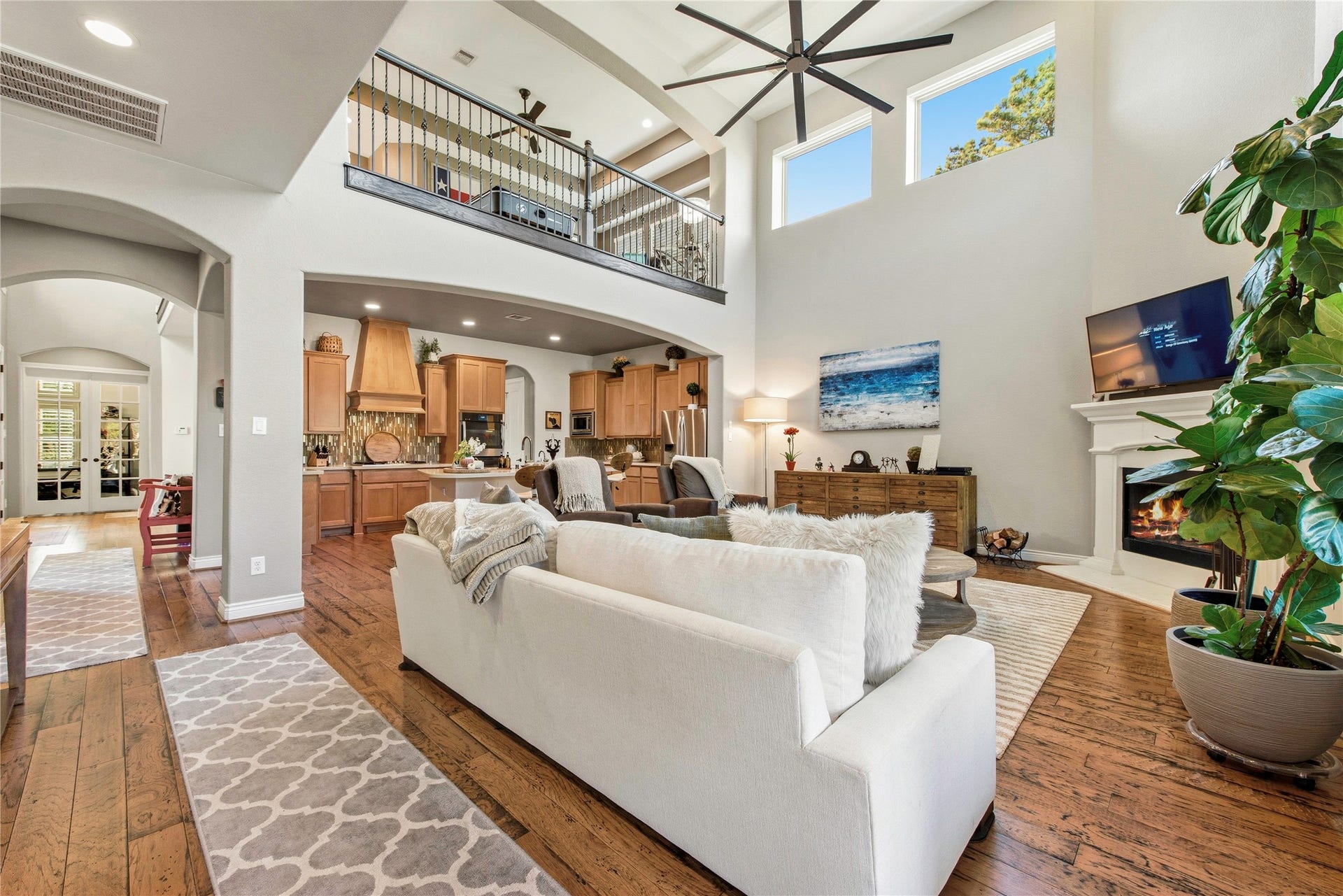 Expansive great room with dramatic ceiling height, fireplace and open-concept design.