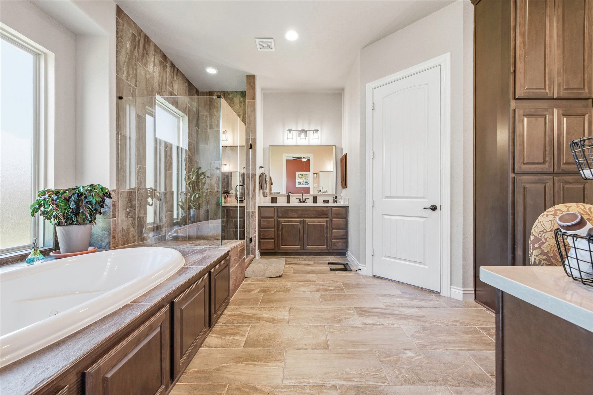 Bright bathroom showcasing dual sinks, ample storage and natural light.