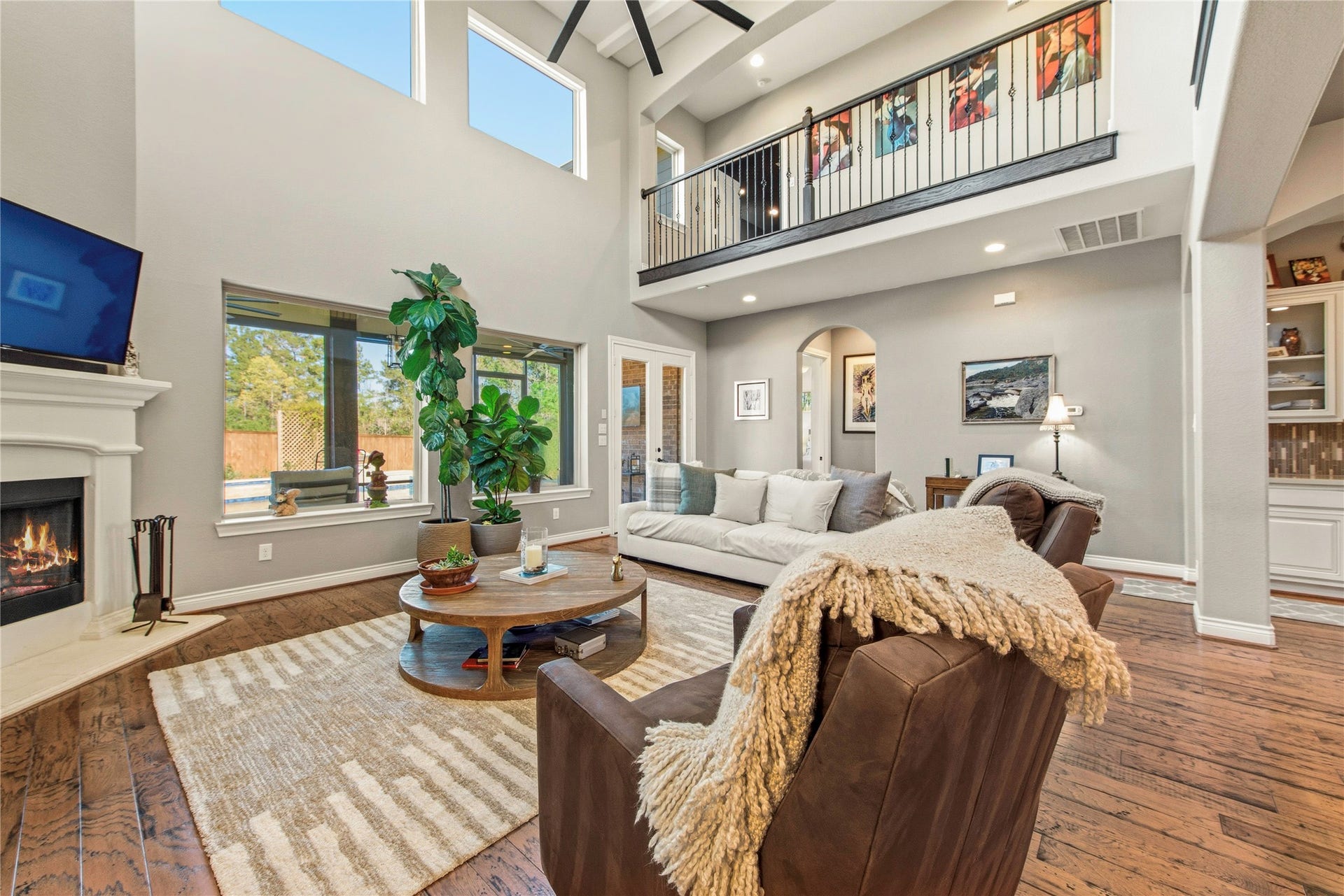 Bright living area featuring large windows, hardwood flooring and open sightlines throughout the home.