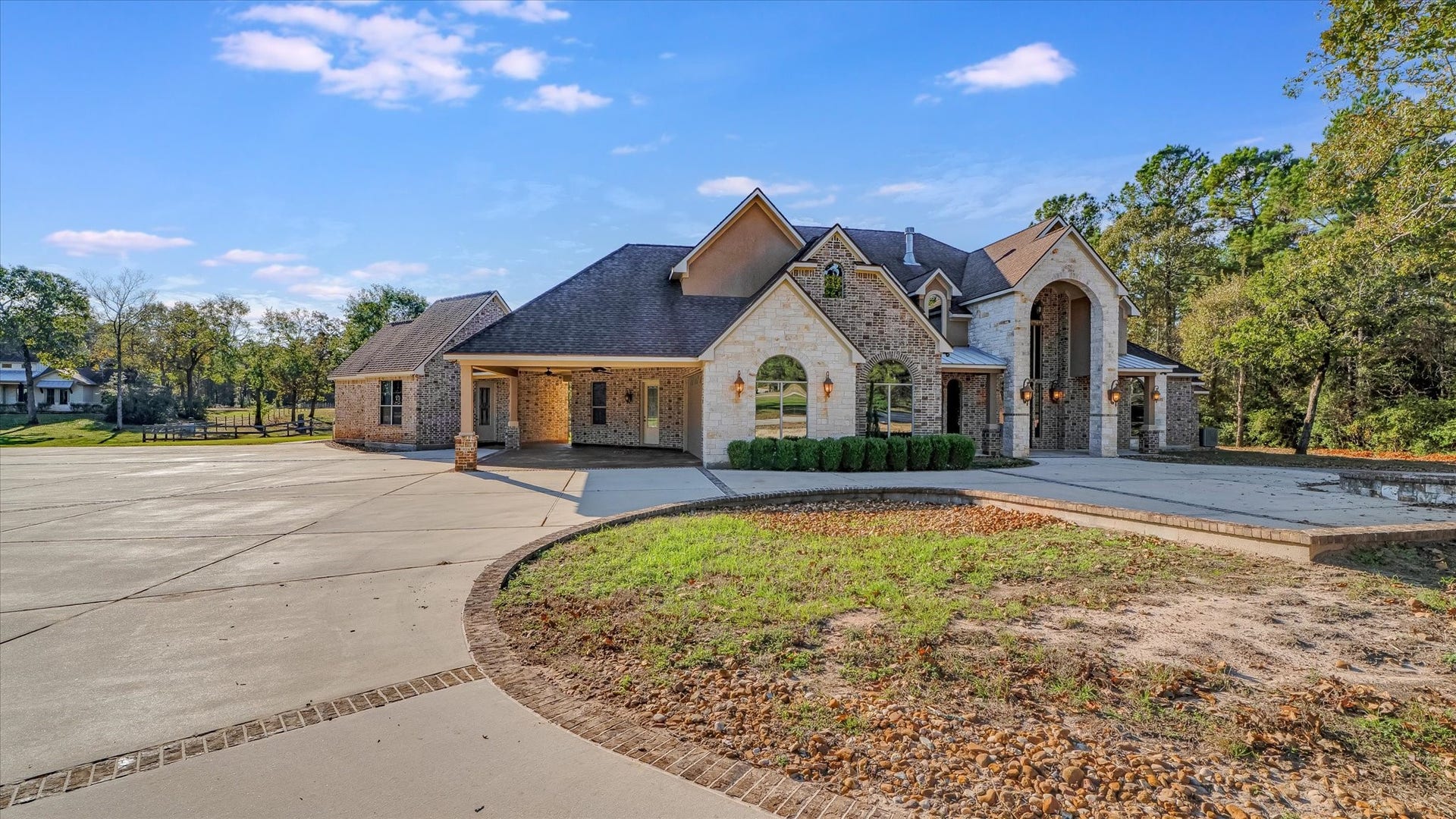 8071 Stacy Diane Drive, Montgomery, TX 77316 This stunning home features a spacious brick and stone exterior with elegant archways and a large driveway. Surrounded by lush greenery, it offers a serene and private setting perfect for a family residence.