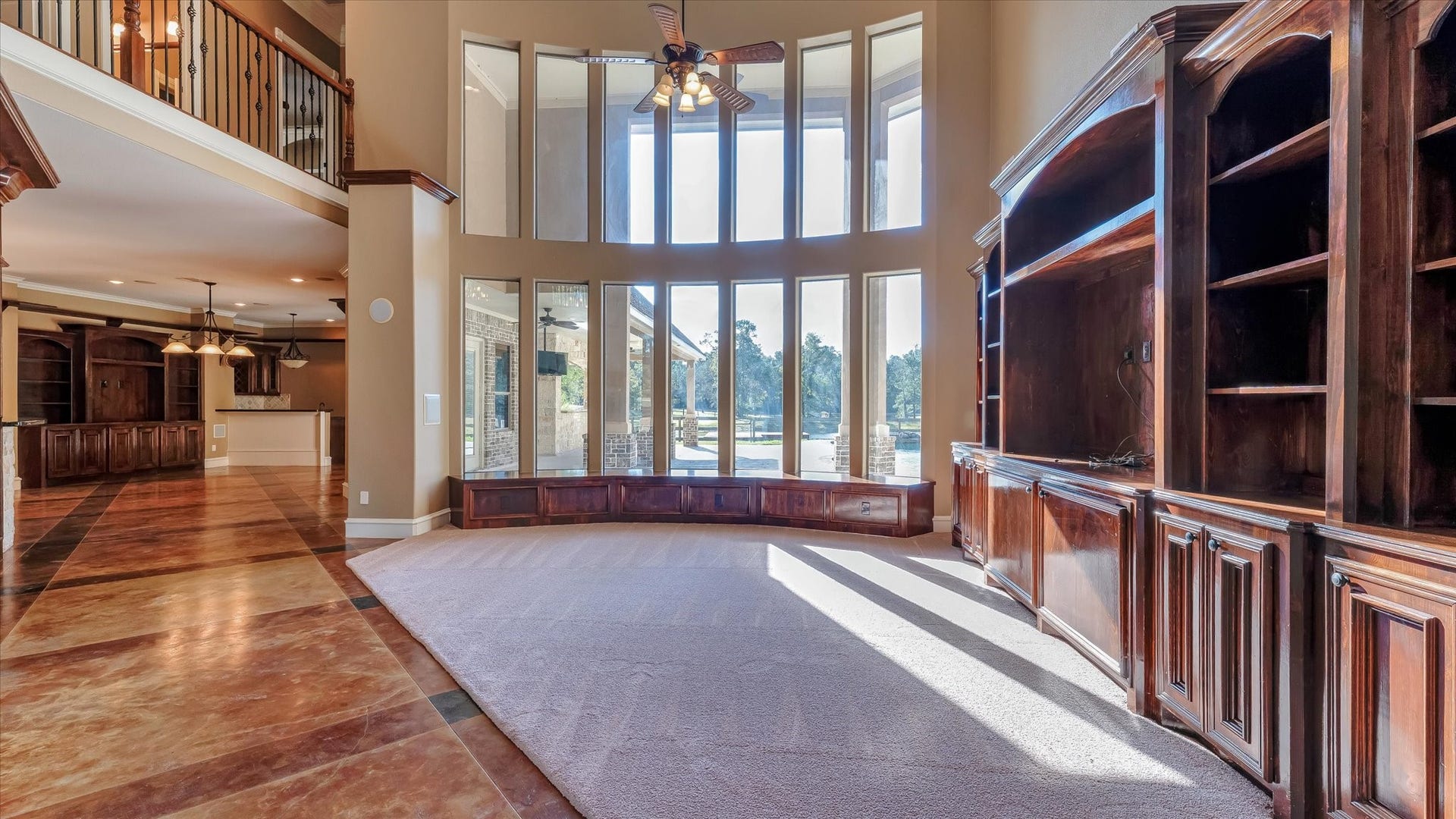 8071 Stacy Diane Drive, Montgomery, TX 77316 This spacious living area features high ceilings, large windows with abundant natural light, elegant wood built-ins, and a blend of carpet and tile flooring. The open layout seamlessly connects to a modern kitchen, perfect for entertaining.