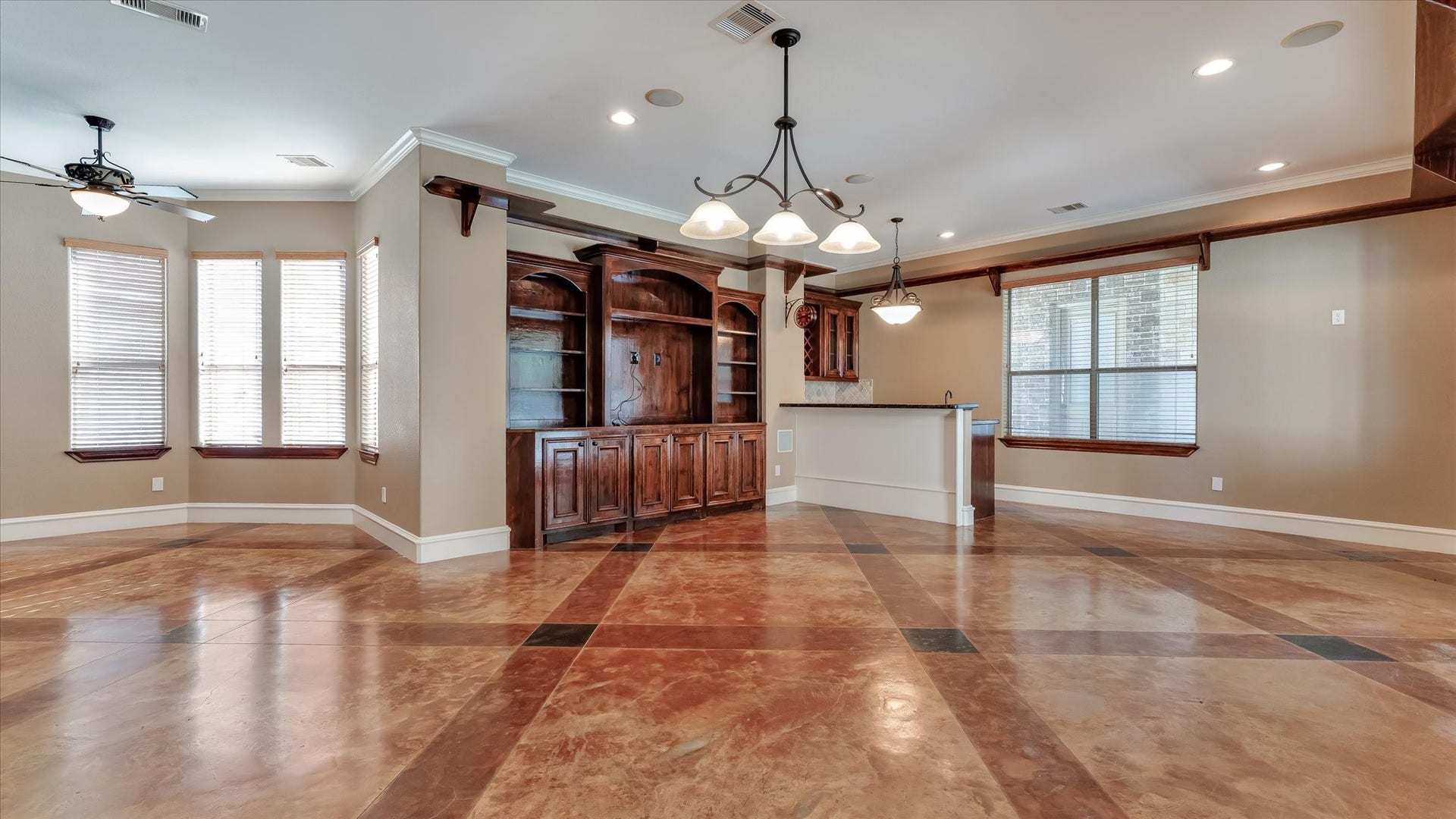 8071 Stacy Diane Drive, Montgomery, TX 77316 Spacious living area with elegant tile flooring, built-in wooden cabinetry, and abundant natural light. Features include a ceiling fan, modern lighting fixtures, and an open layout that flows into a cozy dining space.