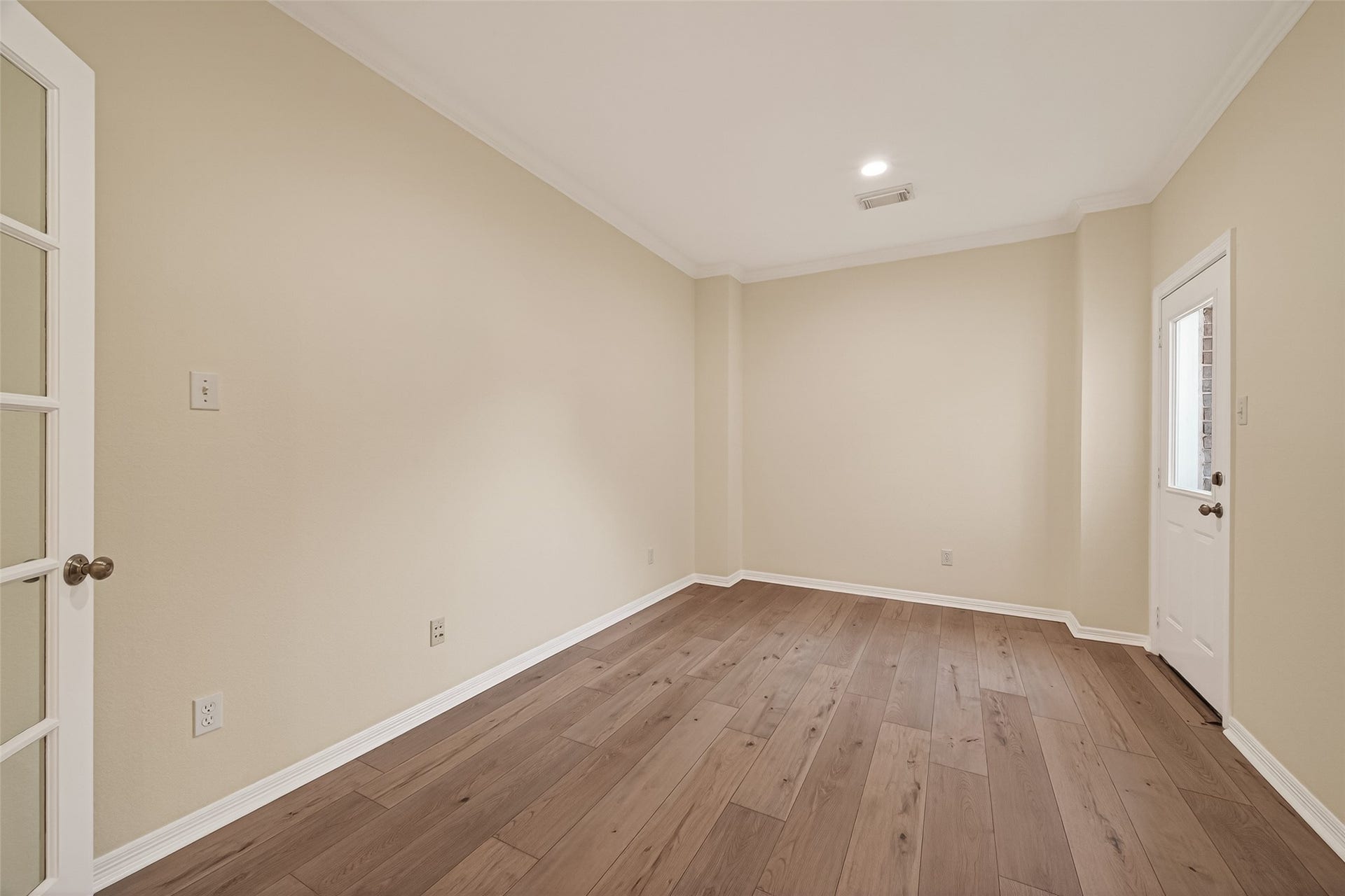 10106 Lost Hollow Lane, Missouri City, TX 77459 This room,features neutral walls, hardwood floors, and a recessed ceiling light. A glass-paneled door and a windowed exterior door provide ample natural light, enhancing its spacious feel. Ideal for a home office or exercise room.