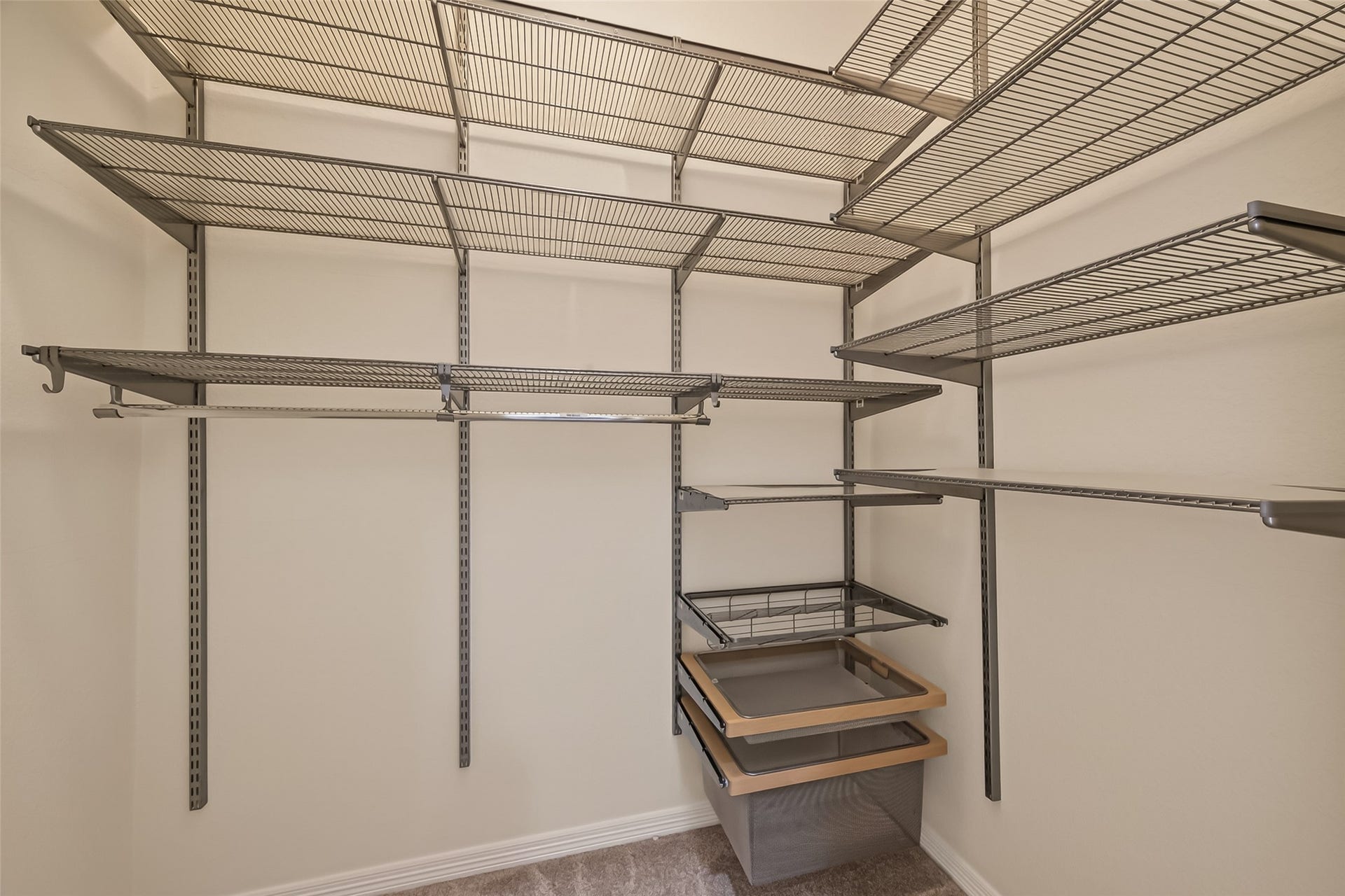 10106 Lost Hollow Lane, Missouri City, TX 77459 This photo shows a spacious walk-in closet featuring multiple metal wire shelves and hanging racks for efficient storage and organization.The primary bedroom closet 2