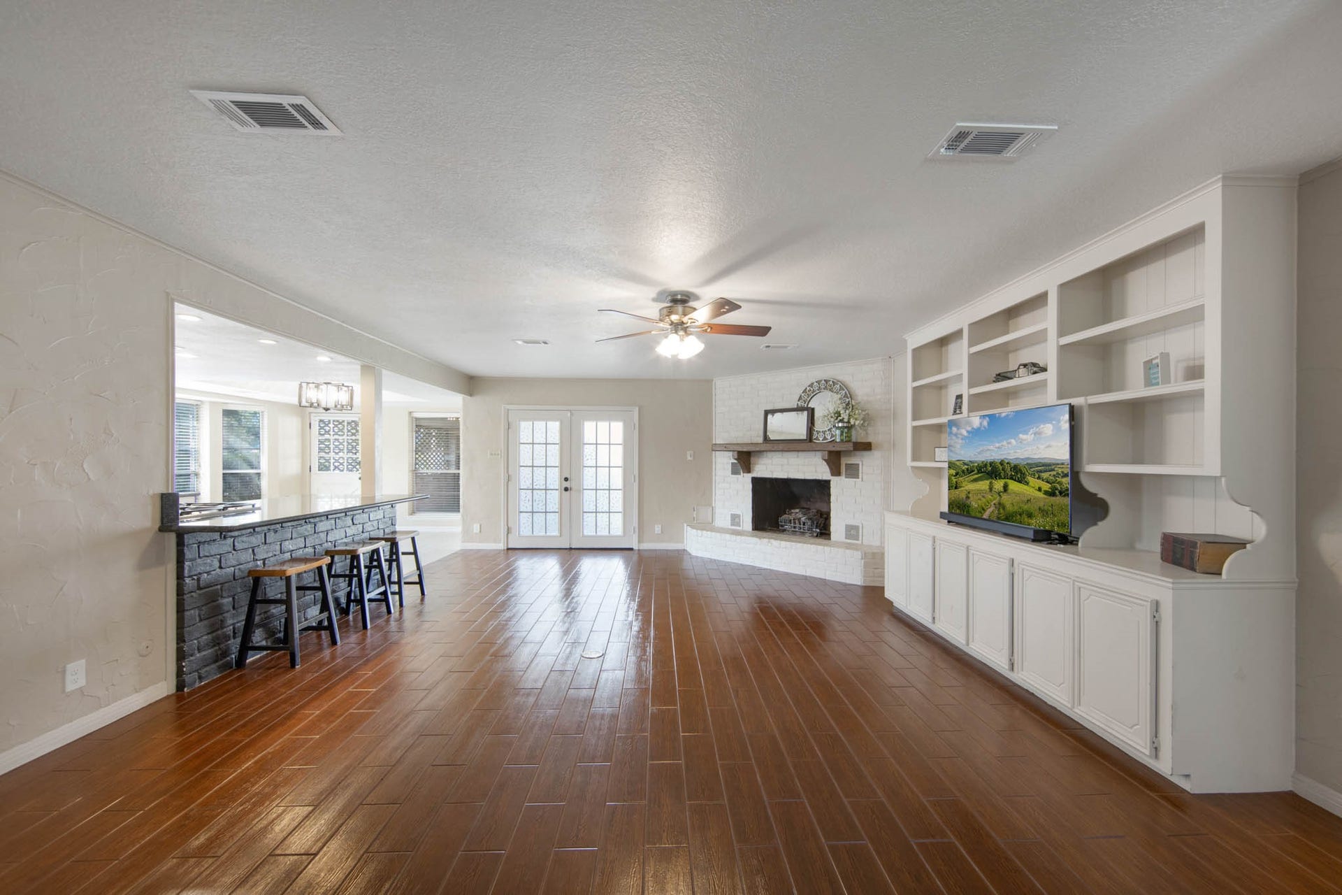 Living Room has build in cabinets, a beautiful brick fireplace, a wood look tile floors