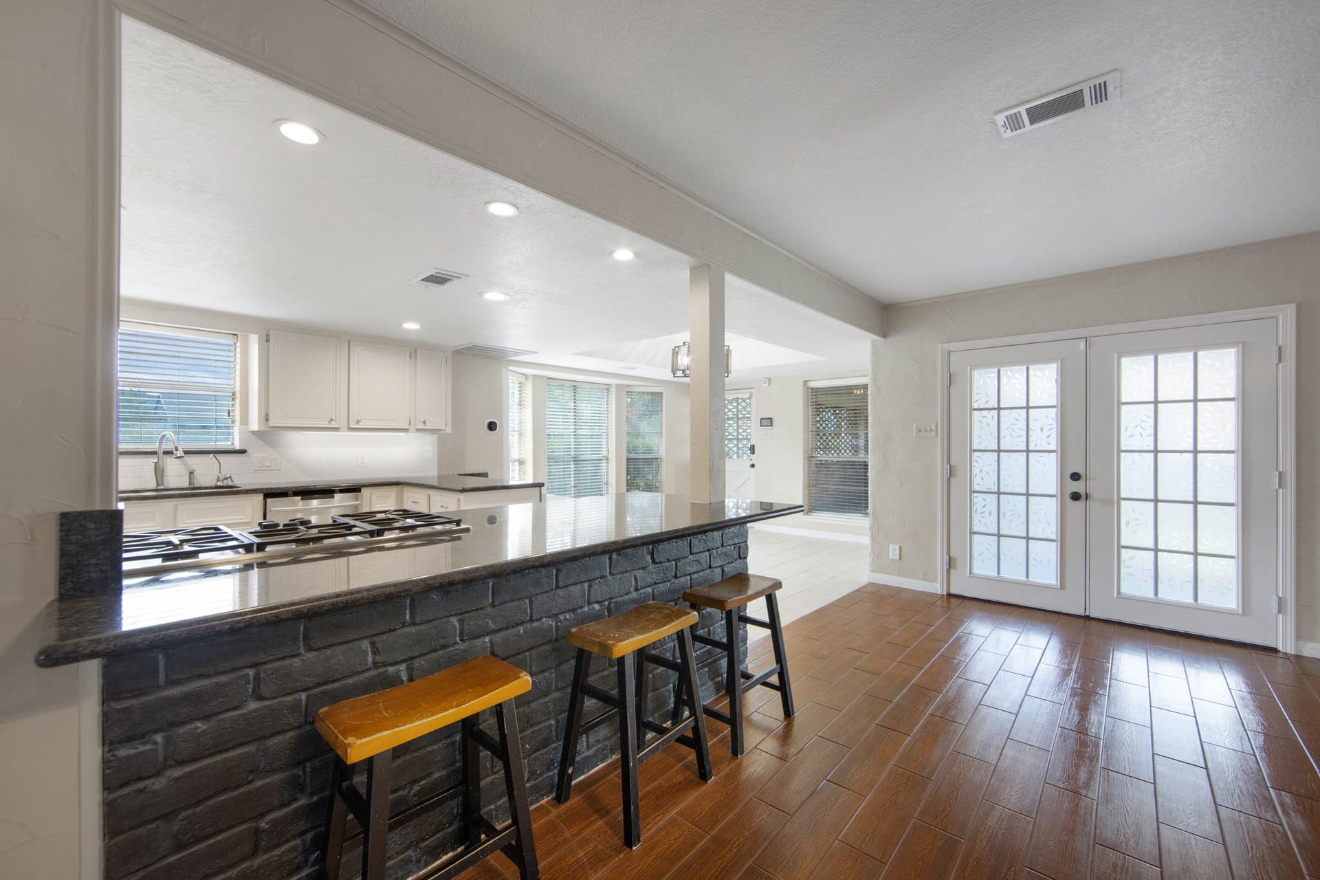Another angle of living room looking towards french doors, the kitchen, and dining room