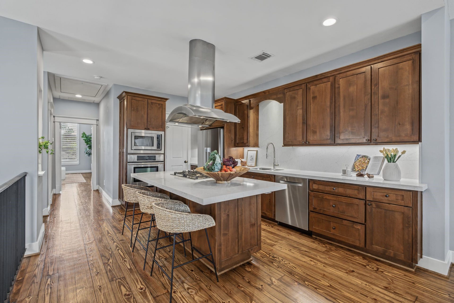 1517 Blair Street, Houston, TX 77008 The open-concept kitchen pairs light countertops with rich wood cabinetry for a clean, contrasting look.