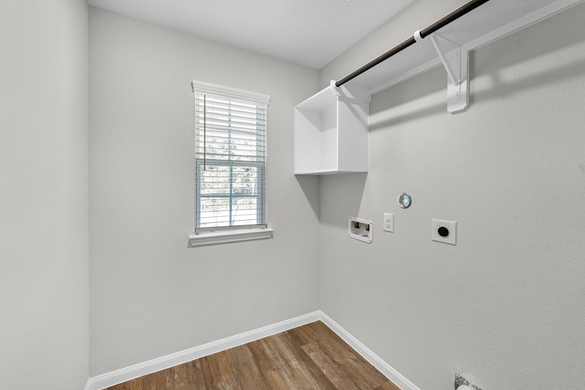 26439 Lakeshore Drive, Hempstead, TX 77445 A functional laundry in the home includes a storage nook, shelf, and hanging rack.