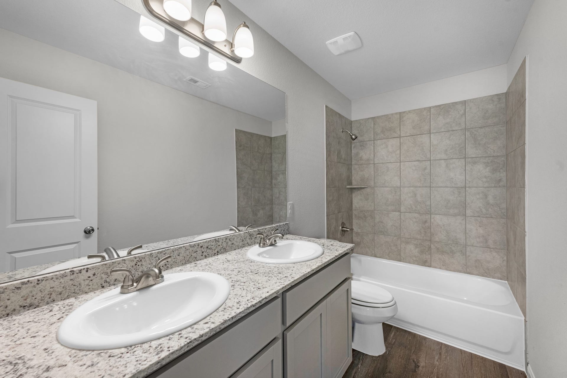 26439 Lakeshore Drive, Hempstead, TX 77445 The primary bathroom includes double sinks, granite counters, and a tub/shower combo with tile surround.
