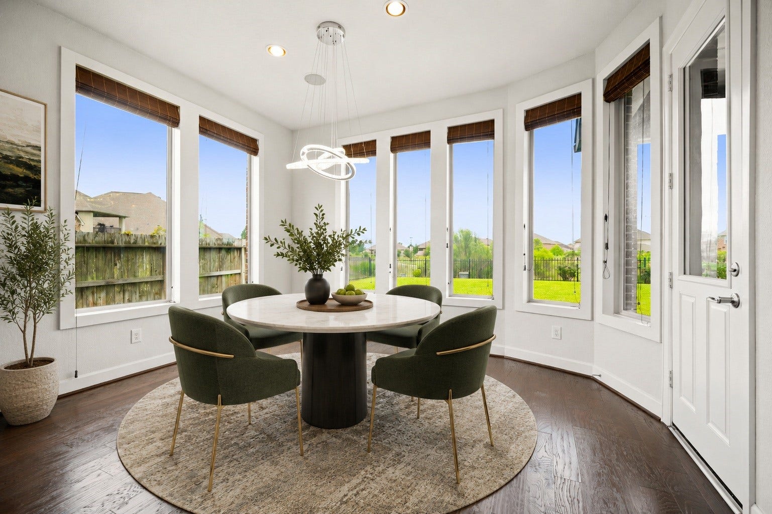 3622 Sage Hollow Drive, Spring, TX 77386 The bright breakfast area serves as a sunny spot for daily dining, featuring a modern light fixture and an entire wall of floor-to-ceiling fixed glass windows looking out to the property's serene grounds. Virtually staged.